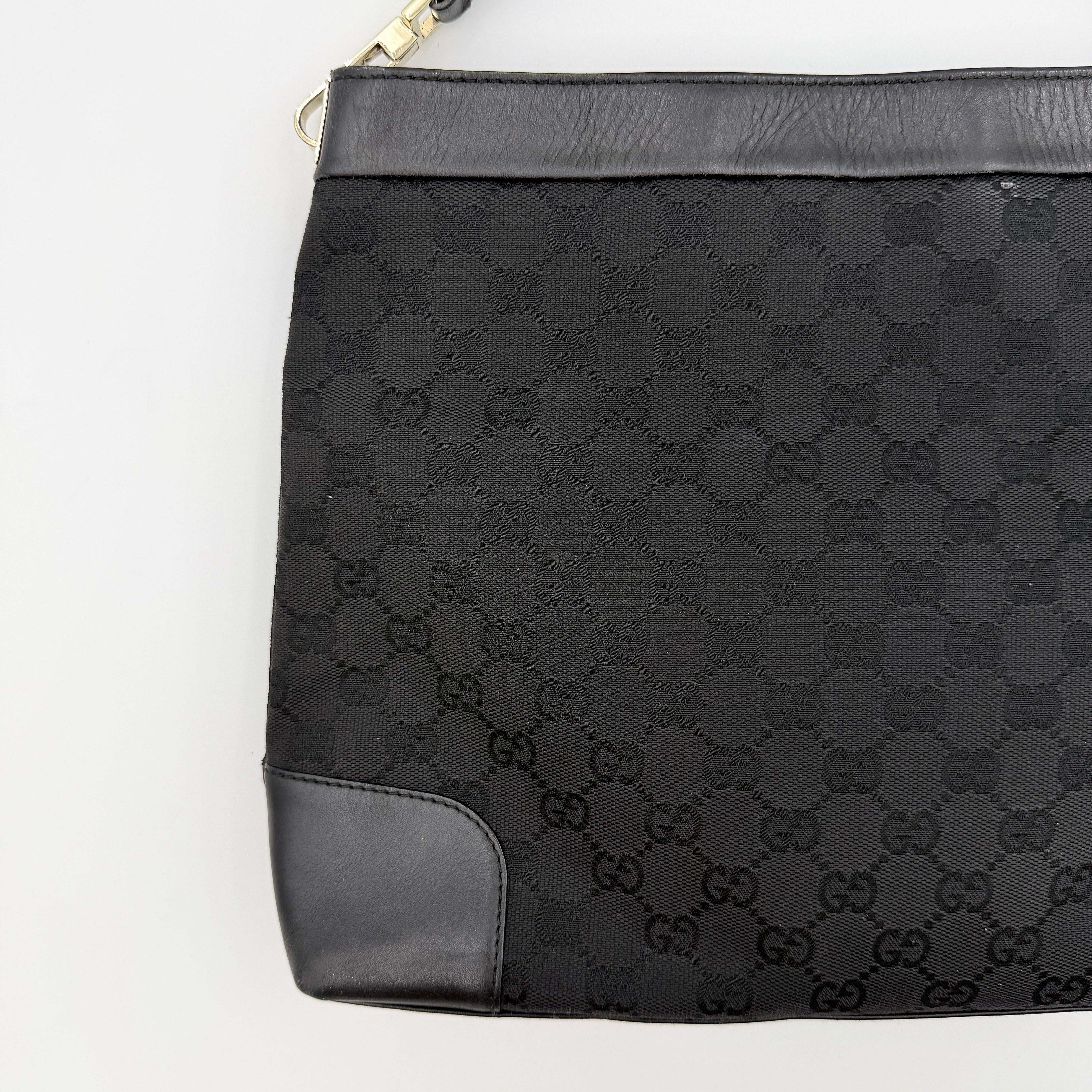 Gucci GG Monogram Bucket Shoulder Bag in black canvas and leather with silver-tone hardware, shown on a white background.