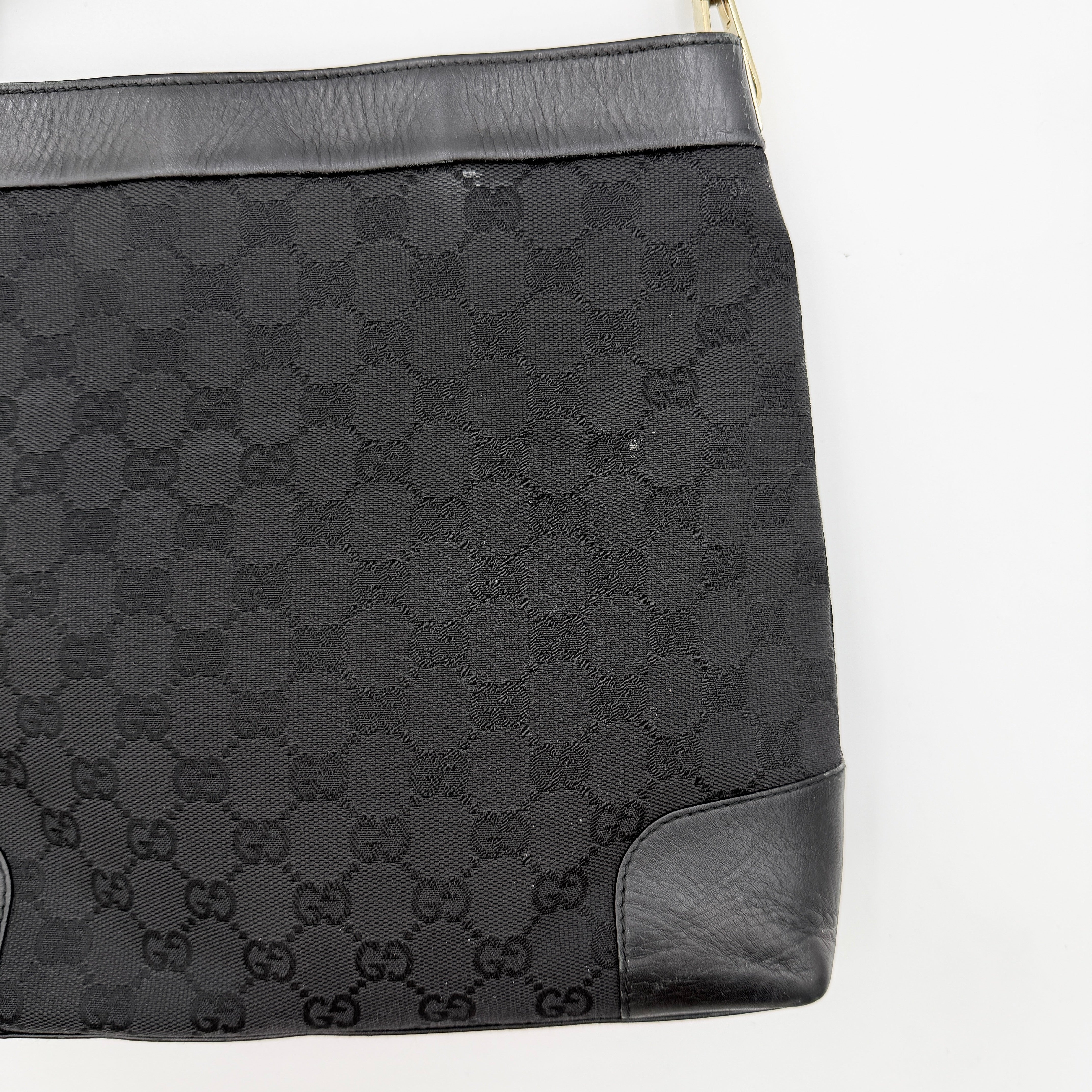 Gucci GG Monogram Bucket Shoulder Bag in black canvas and leather with silver-tone hardware, shown on a white background.