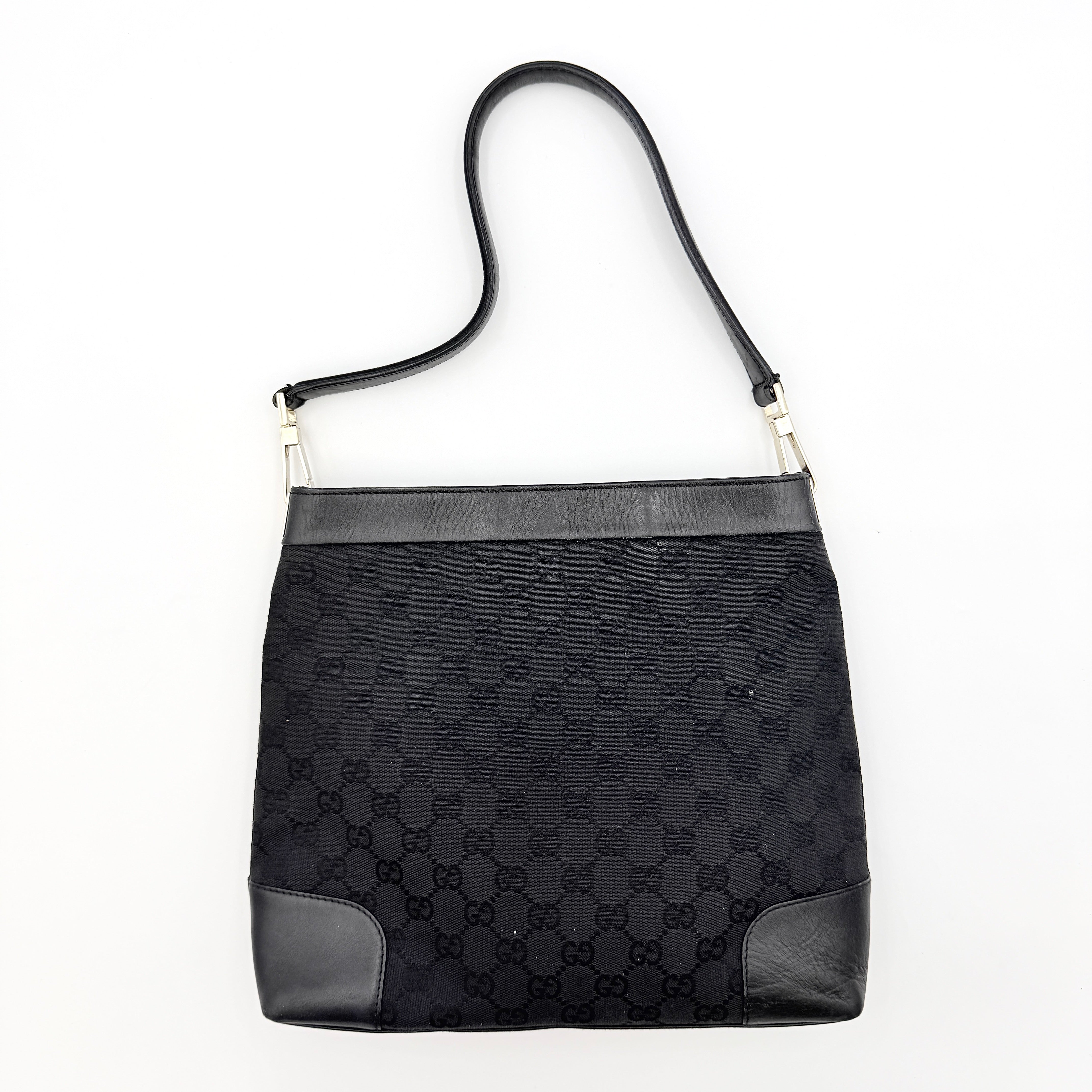 Gucci GG Monogram Bucket Shoulder Bag in black canvas and leather with silver-tone hardware, shown on a white background.
