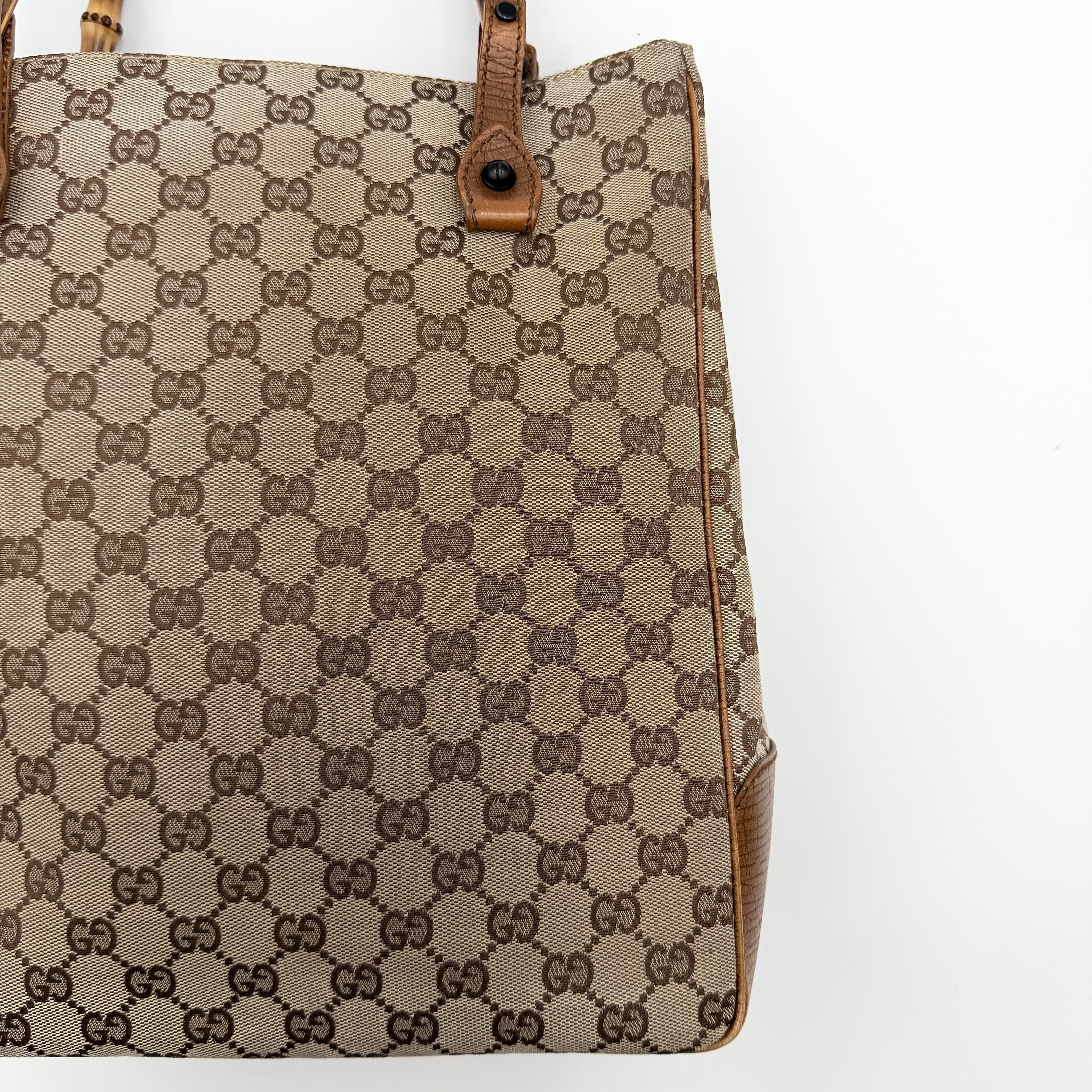 Gucci GG Monogram Bamboo Shoulder Bag in beige and brown canvas with bamboo top handles displayed upright.