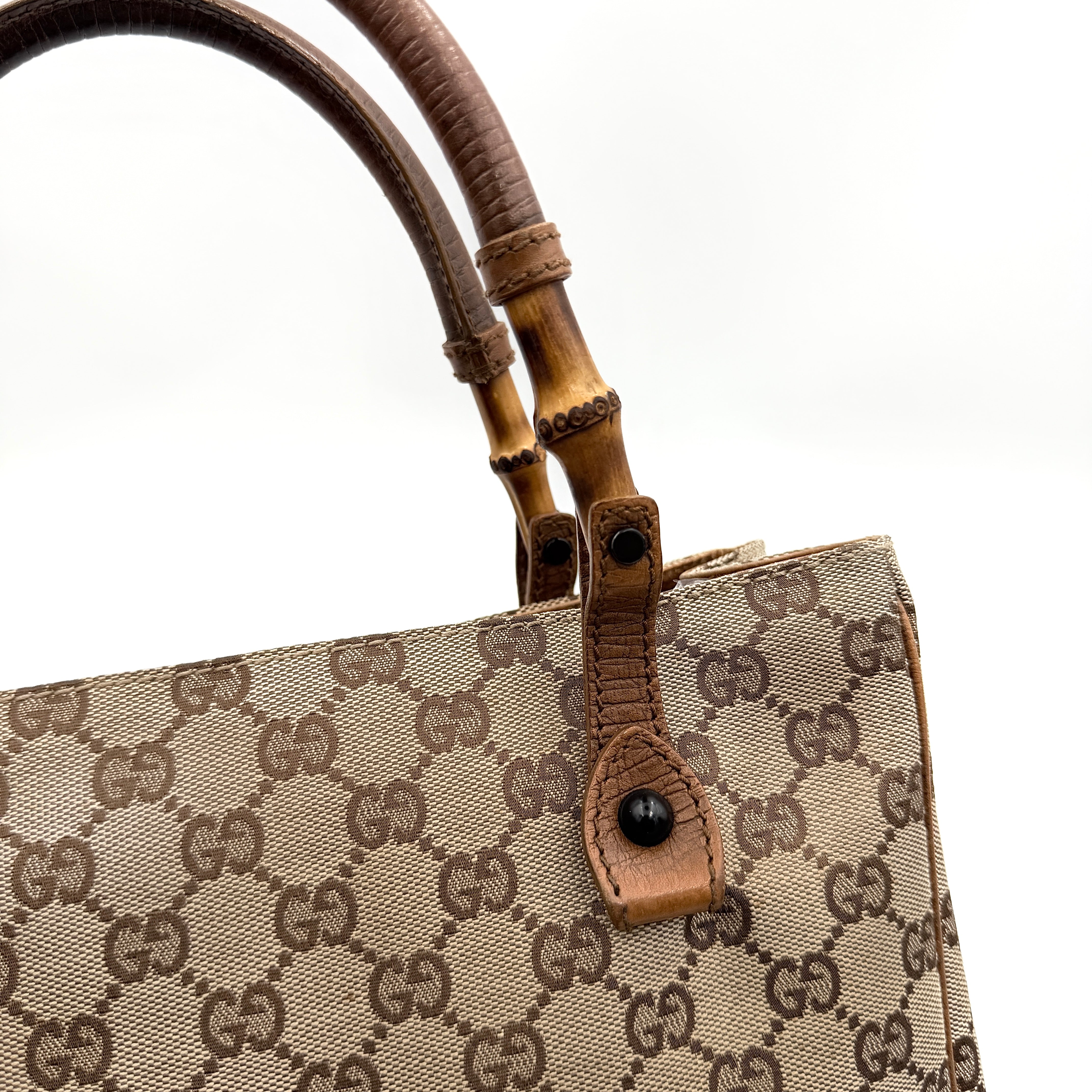 Gucci GG Monogram Bamboo Shoulder Bag in beige and brown canvas with bamboo top handles displayed upright.