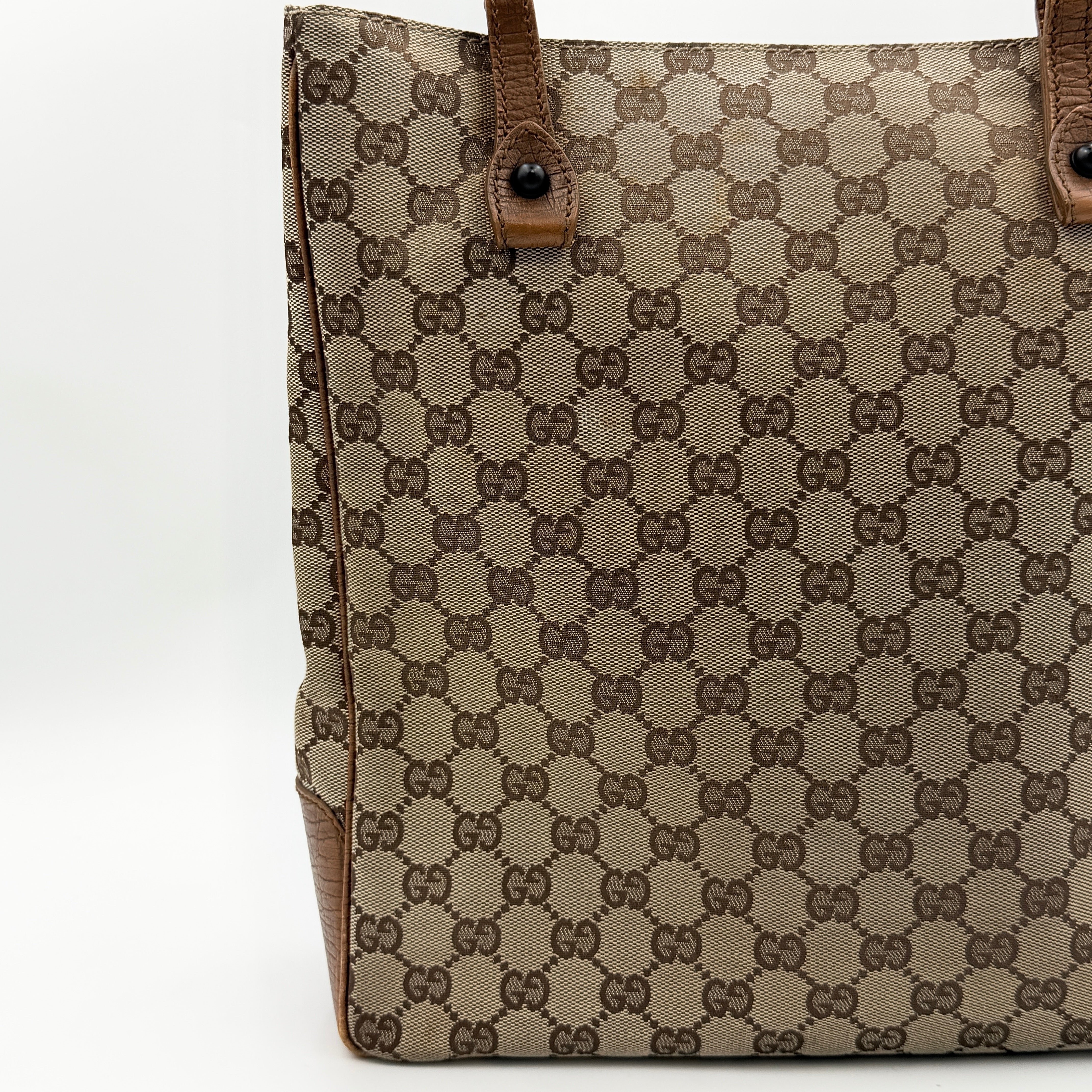 Gucci GG Monogram Bamboo Shoulder Bag in beige and brown canvas with bamboo top handles displayed upright.