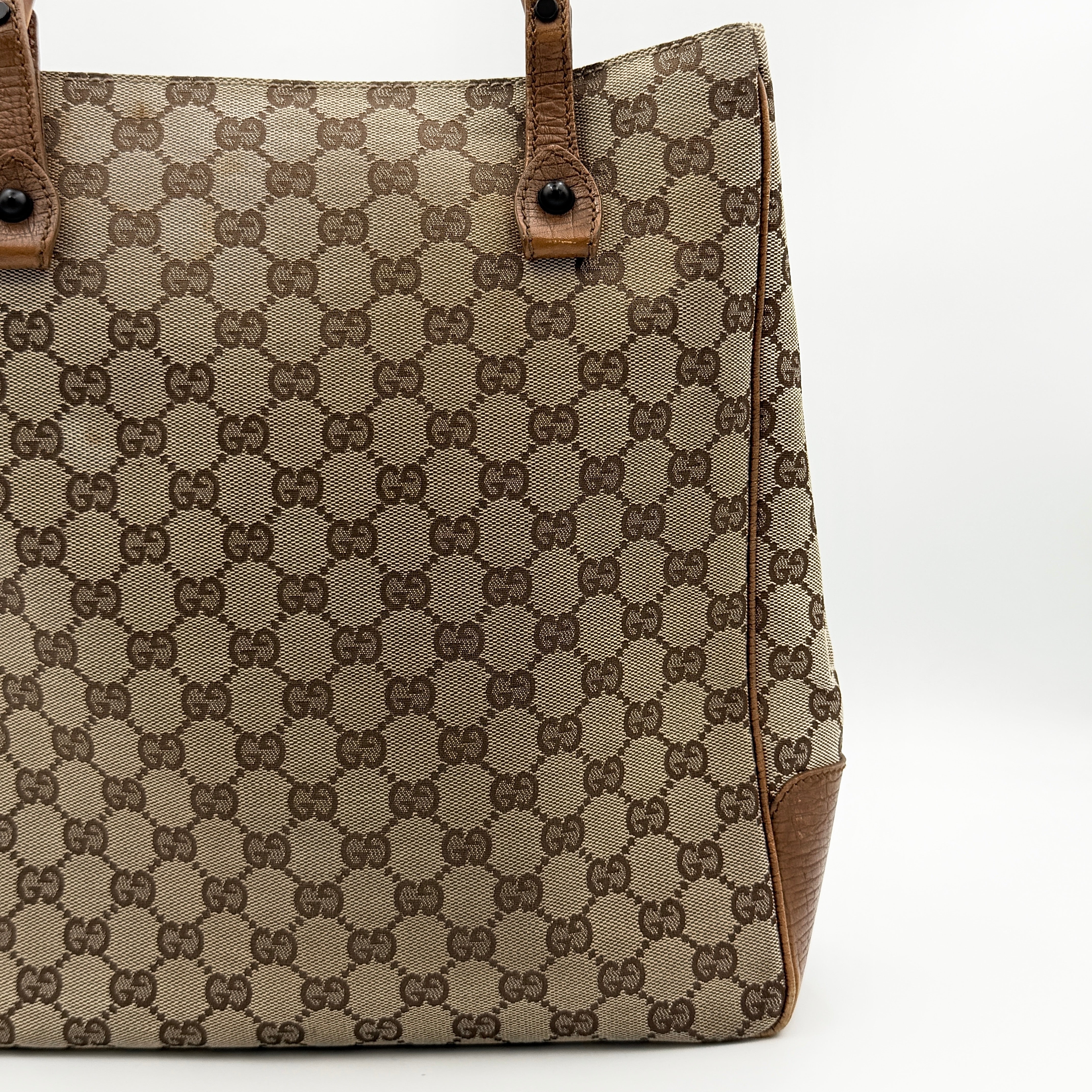 Gucci GG Monogram Bamboo Shoulder Bag in beige and brown canvas with bamboo top handles displayed upright.