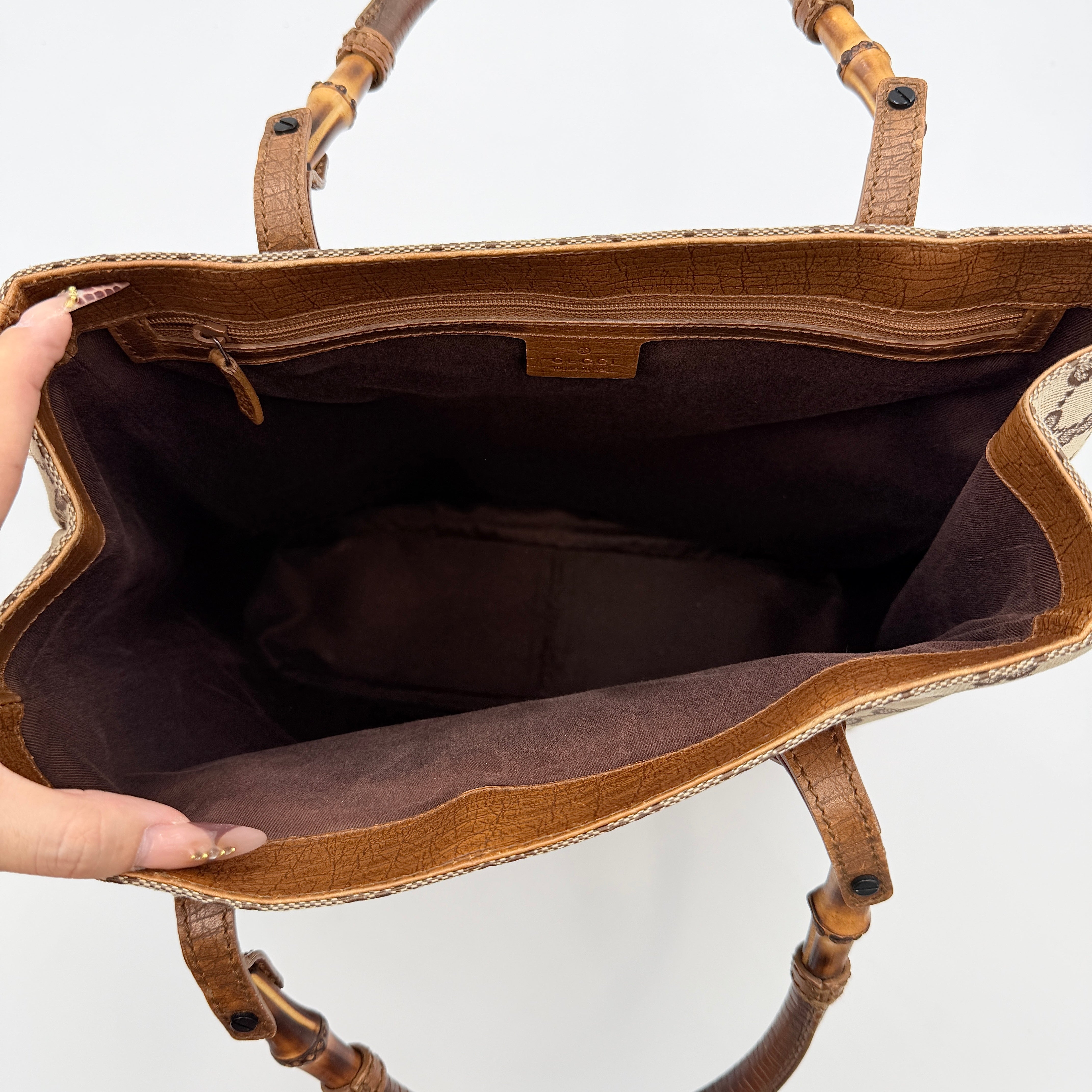 Gucci GG Monogram Bamboo Shoulder Bag in beige and brown canvas with bamboo top handles displayed upright.