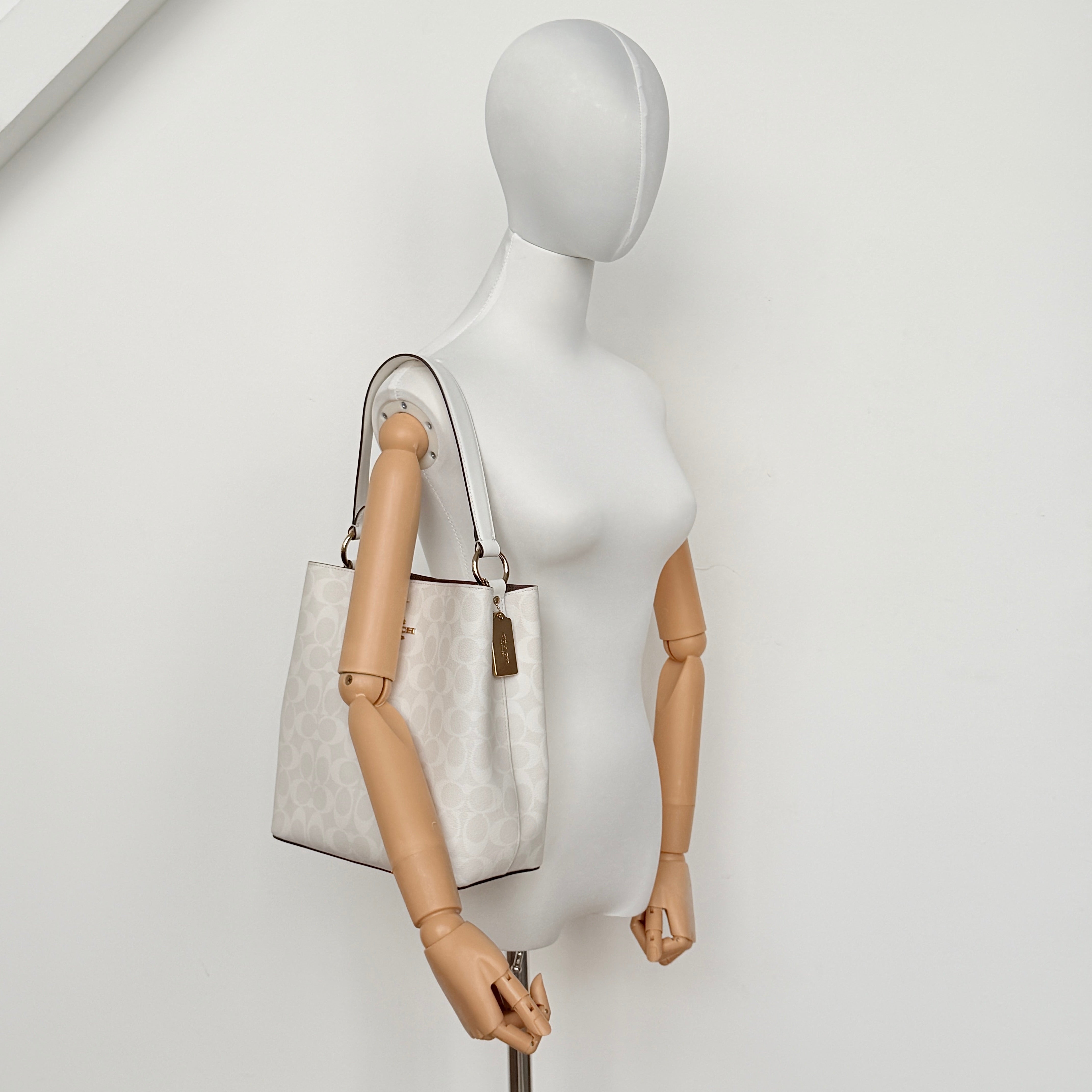 Coach Signature Town Bucket Shoulder Bag in white monogram canvas, shown with detachable strap and gold-tone hardware.