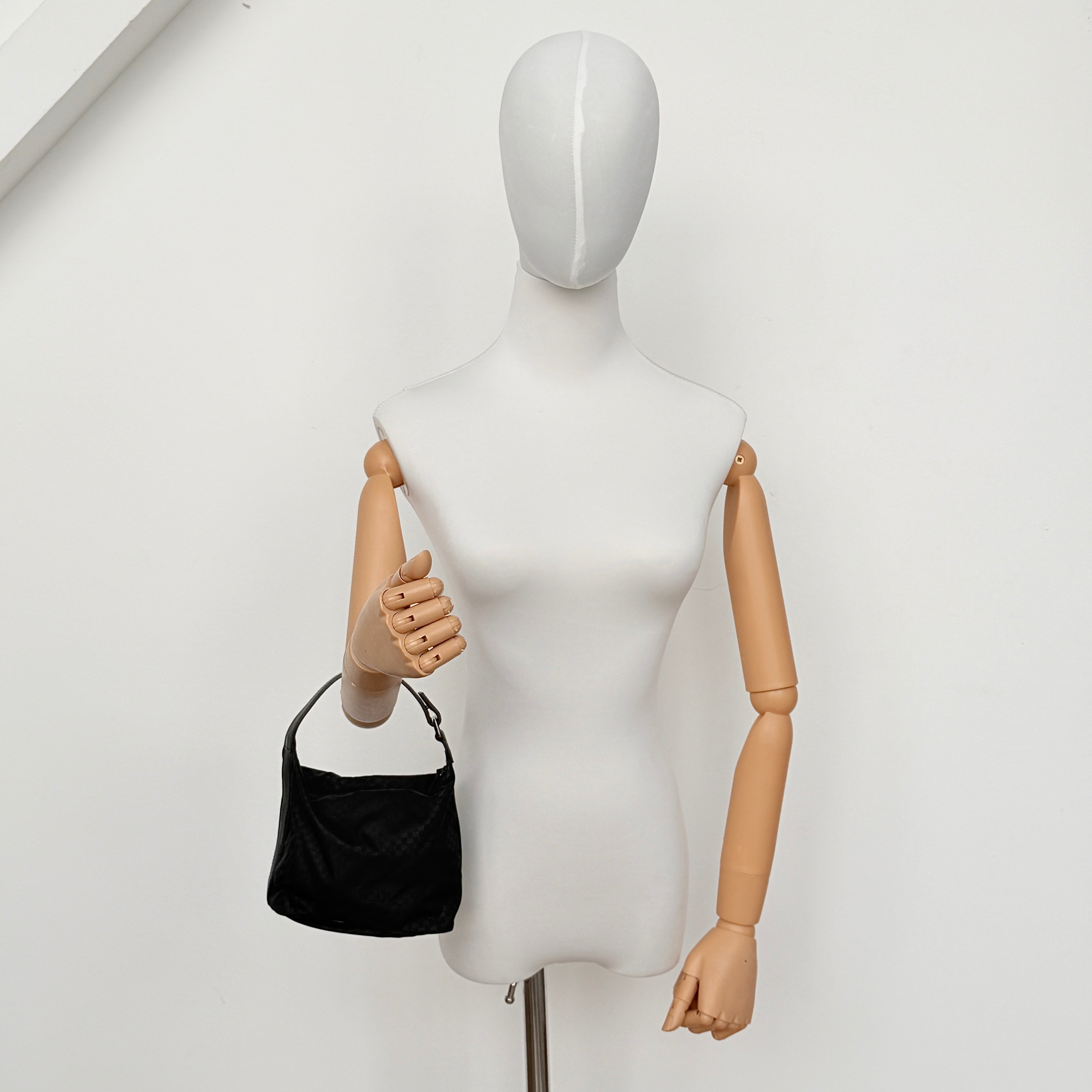 Gucci GG Monogram Mini Hobo black nylon shoulder bag with leather trim and silver-tone hardware, displayed on a plain background.