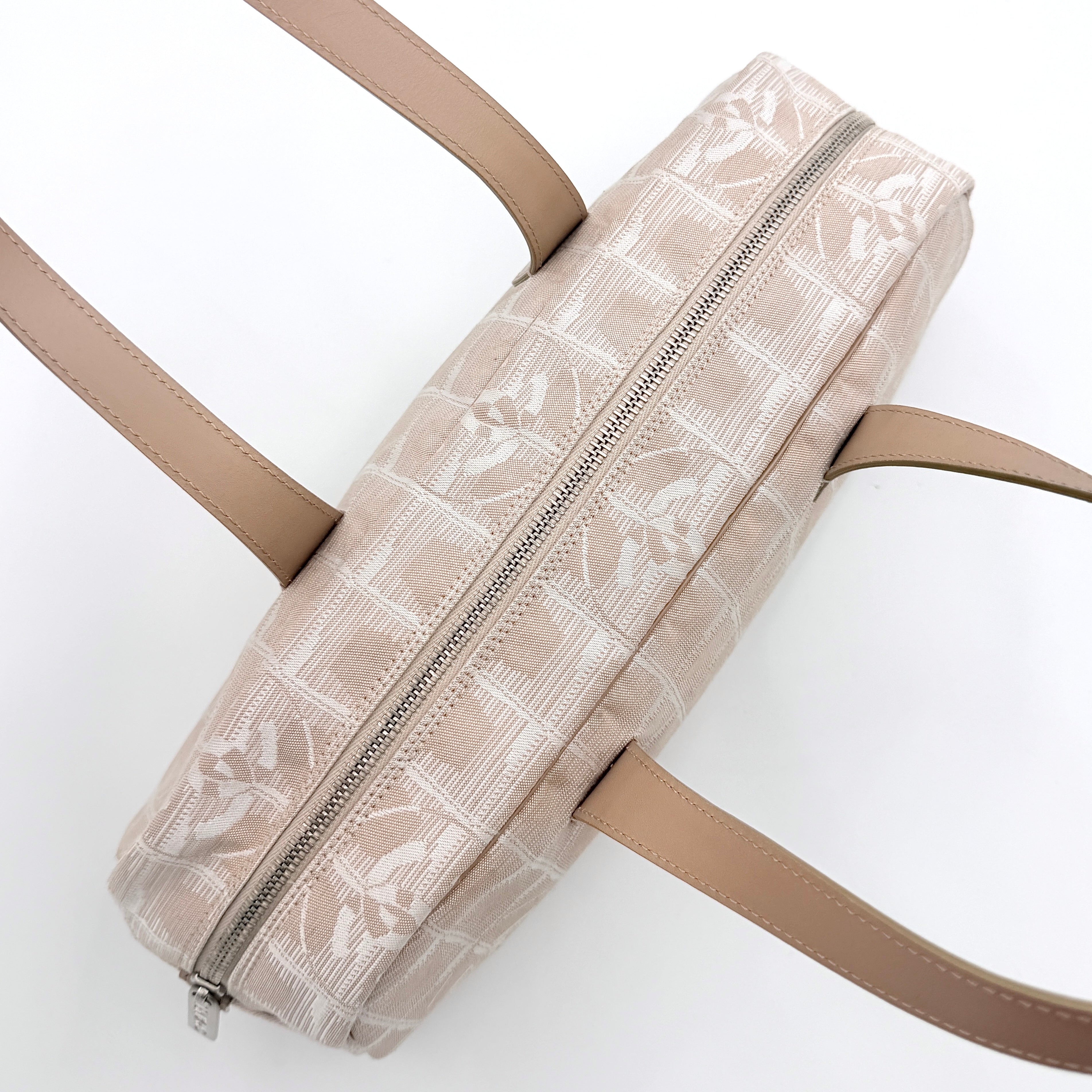 Chanel Travel Mini Boston Bag in beige nylon with CC motif and tan leather handles, shown in front view.