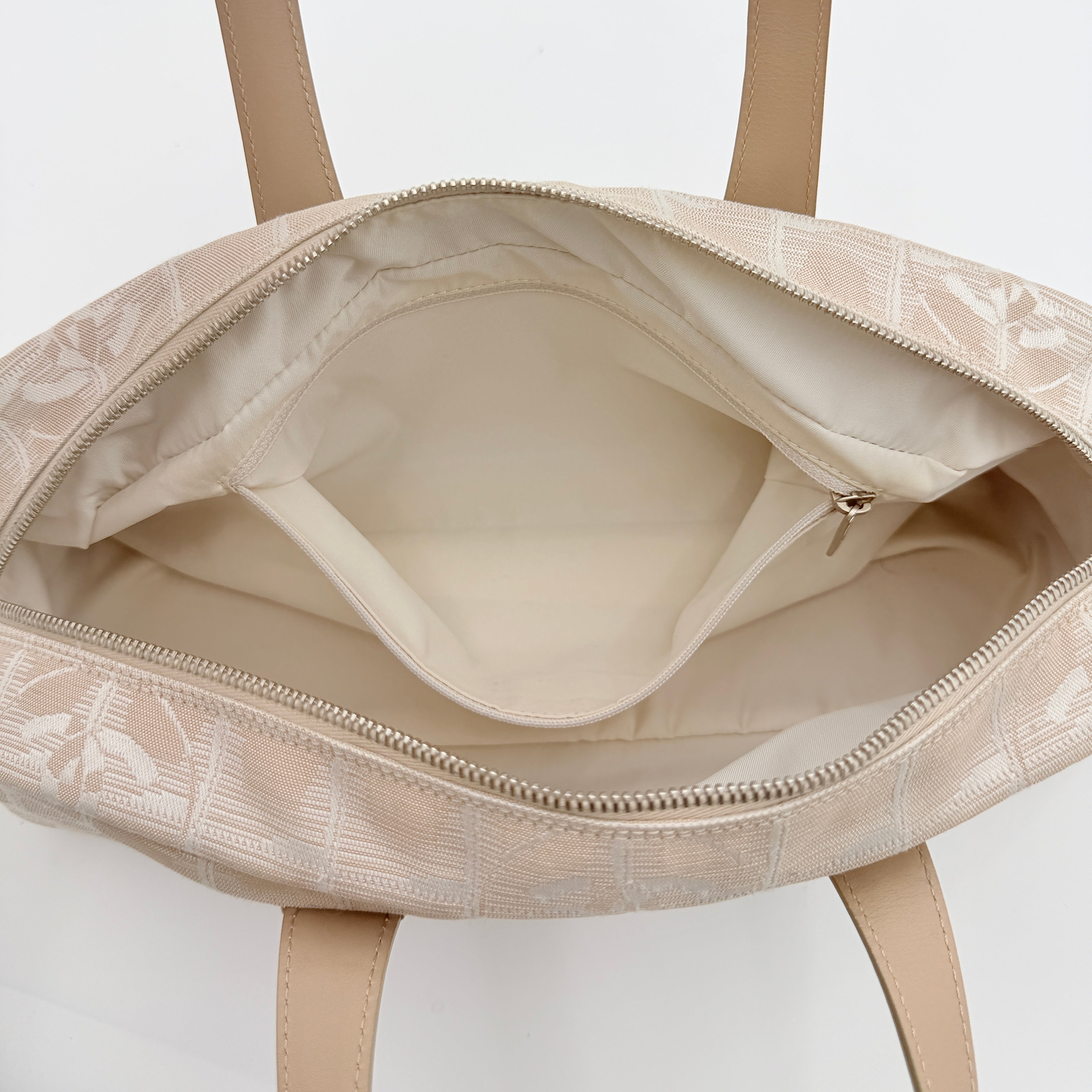 Chanel Travel Mini Boston Bag in beige nylon with CC motif and tan leather handles, shown in front view.