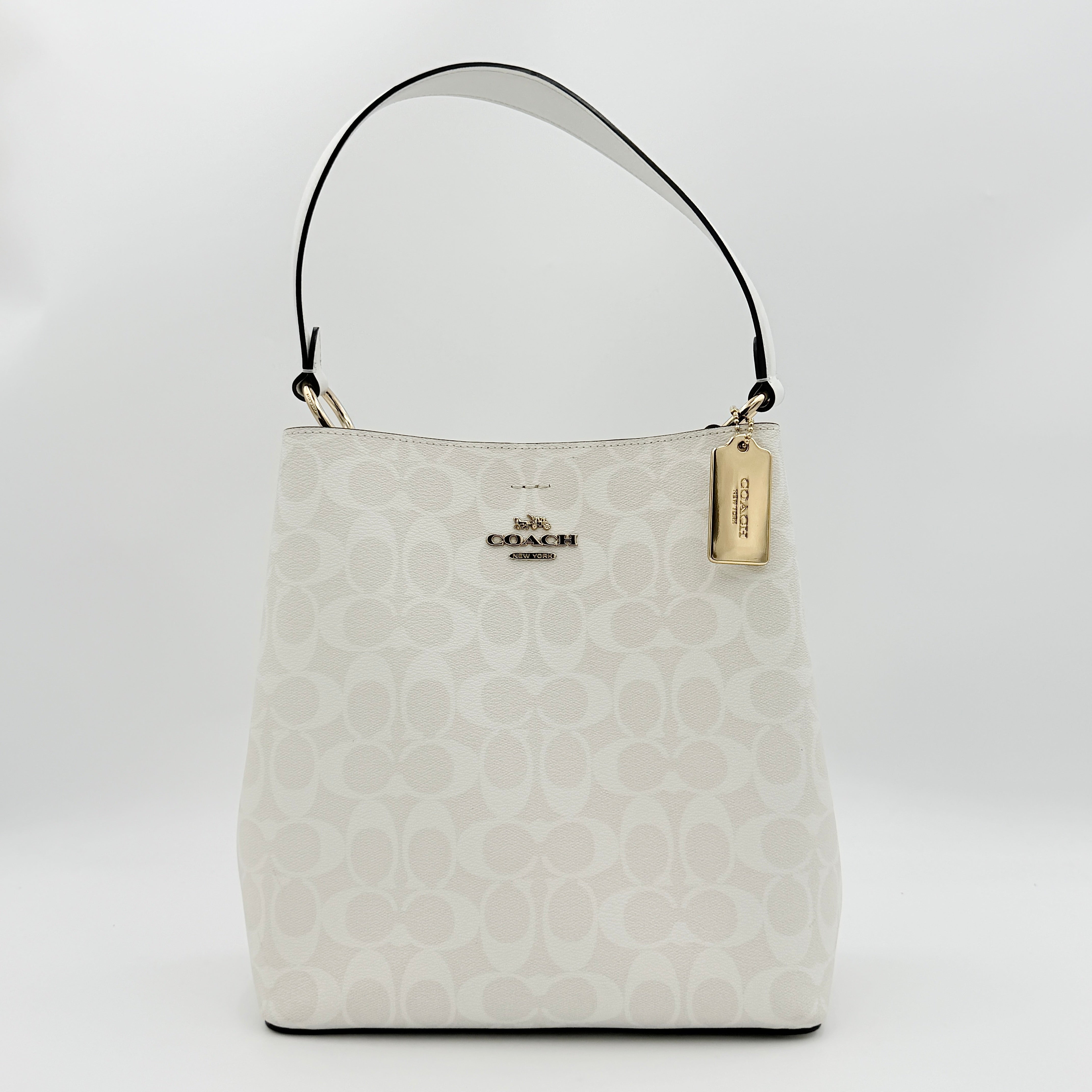 Coach Signature Town Bucket Shoulder Bag in white monogram canvas, shown with detachable strap and gold-tone hardware.