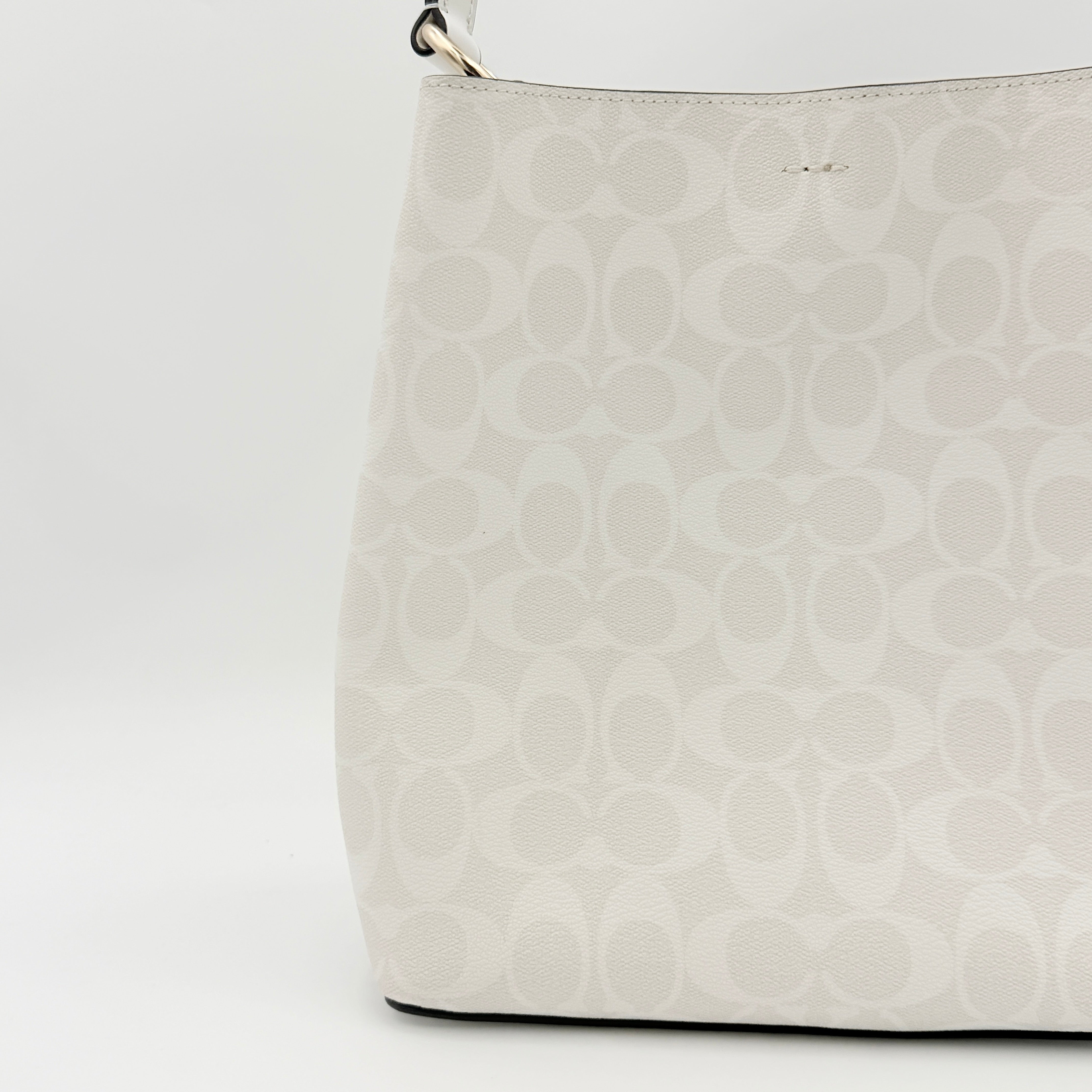 Coach Signature Town Bucket Shoulder Bag in white monogram canvas, shown with detachable strap and gold-tone hardware.