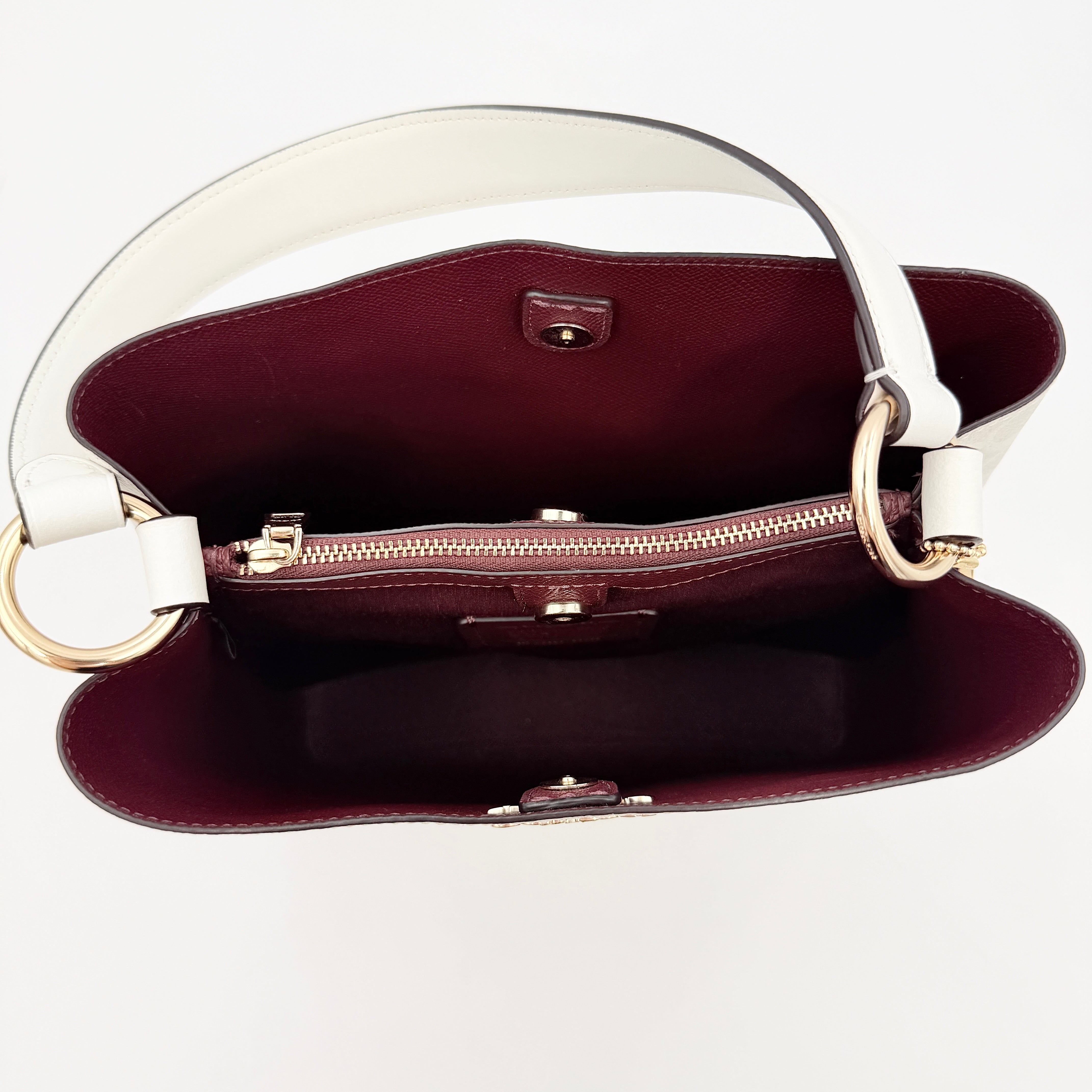 Coach Signature Town Bucket Shoulder Bag in white monogram canvas, shown with detachable strap and gold-tone hardware.