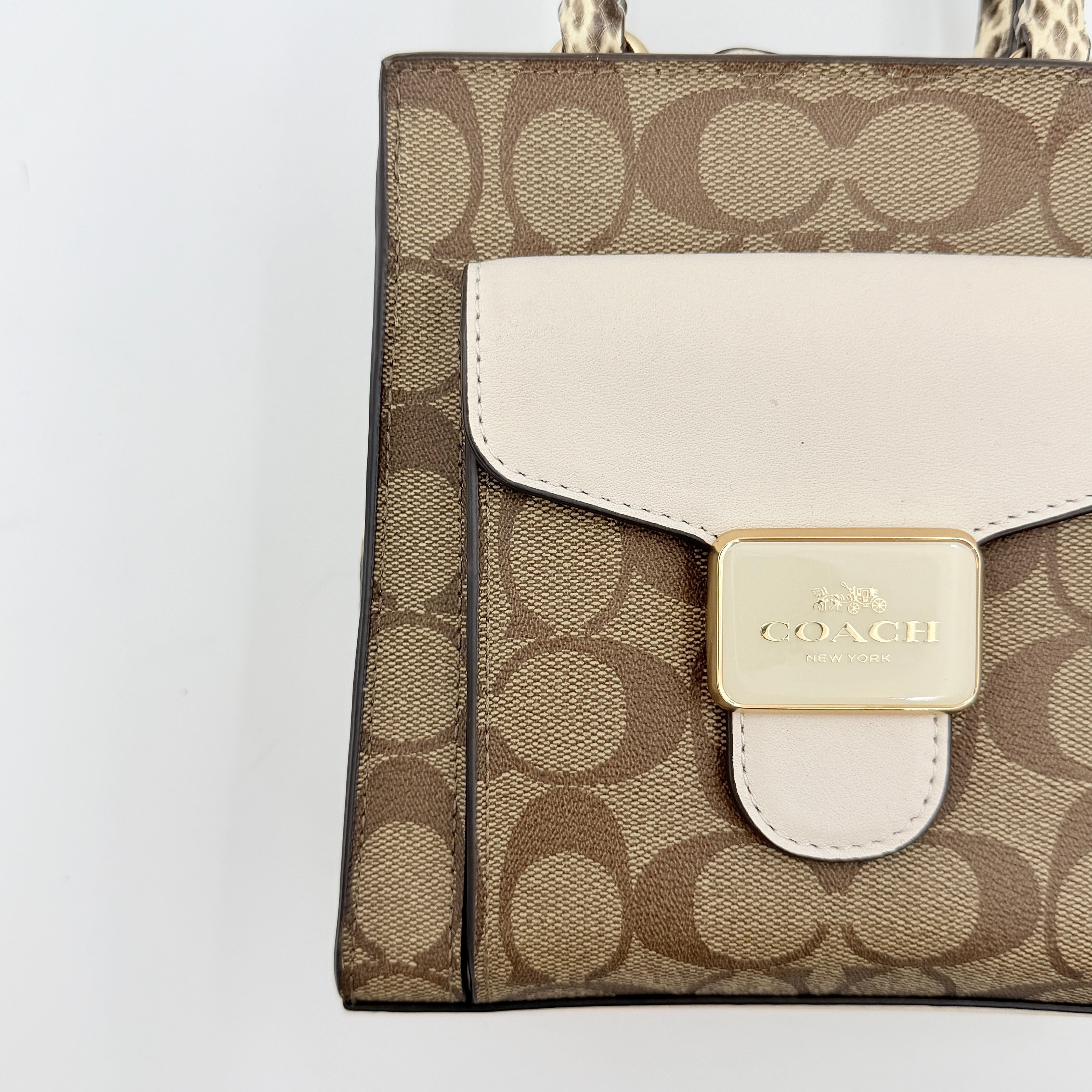 Coach Mini Pepper HandBag in beige canvas with white leather and snakeskin-effect handle, styled with detachable crossbody strap.