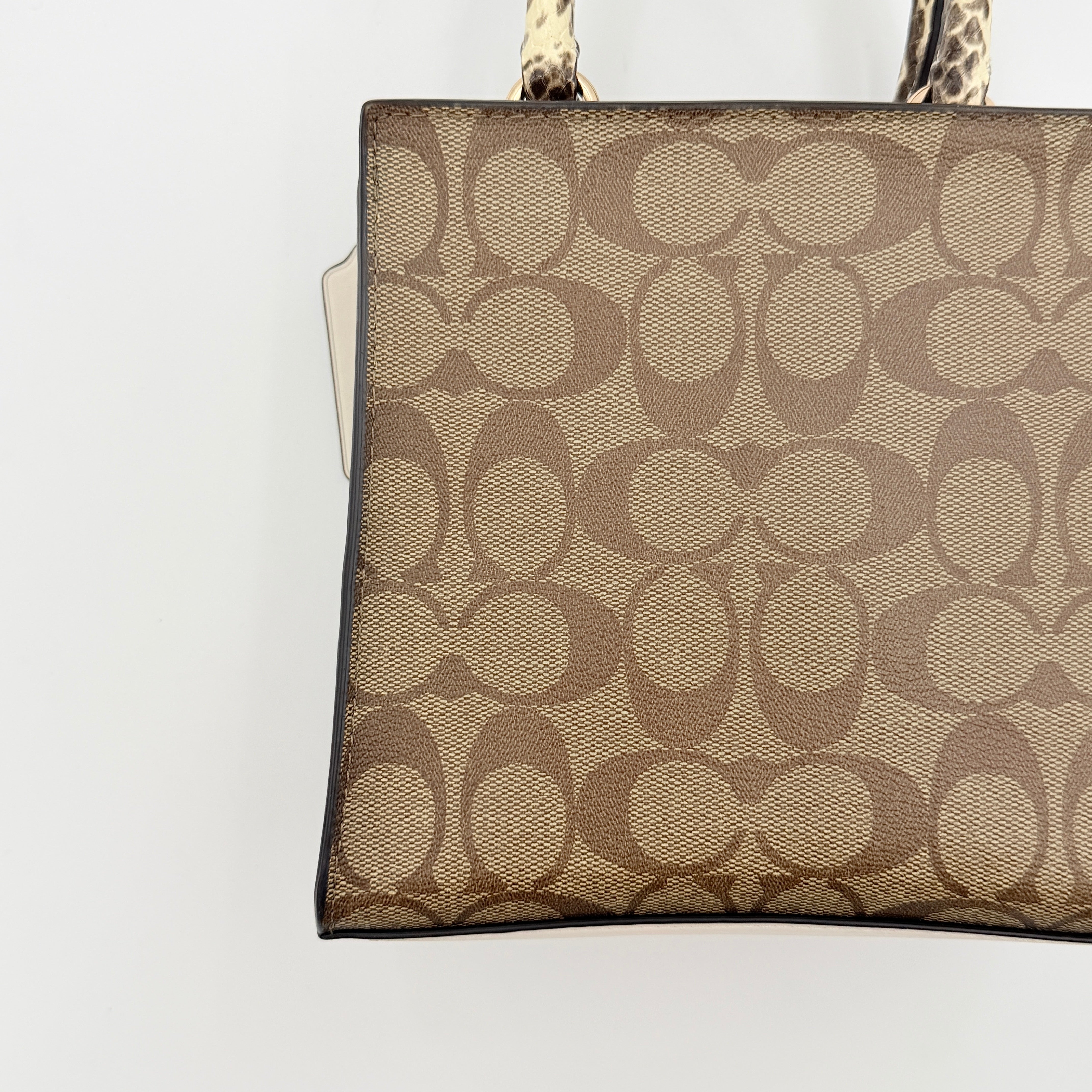 Coach Mini Pepper HandBag in beige canvas with white leather and snakeskin-effect handle, styled with detachable crossbody strap.