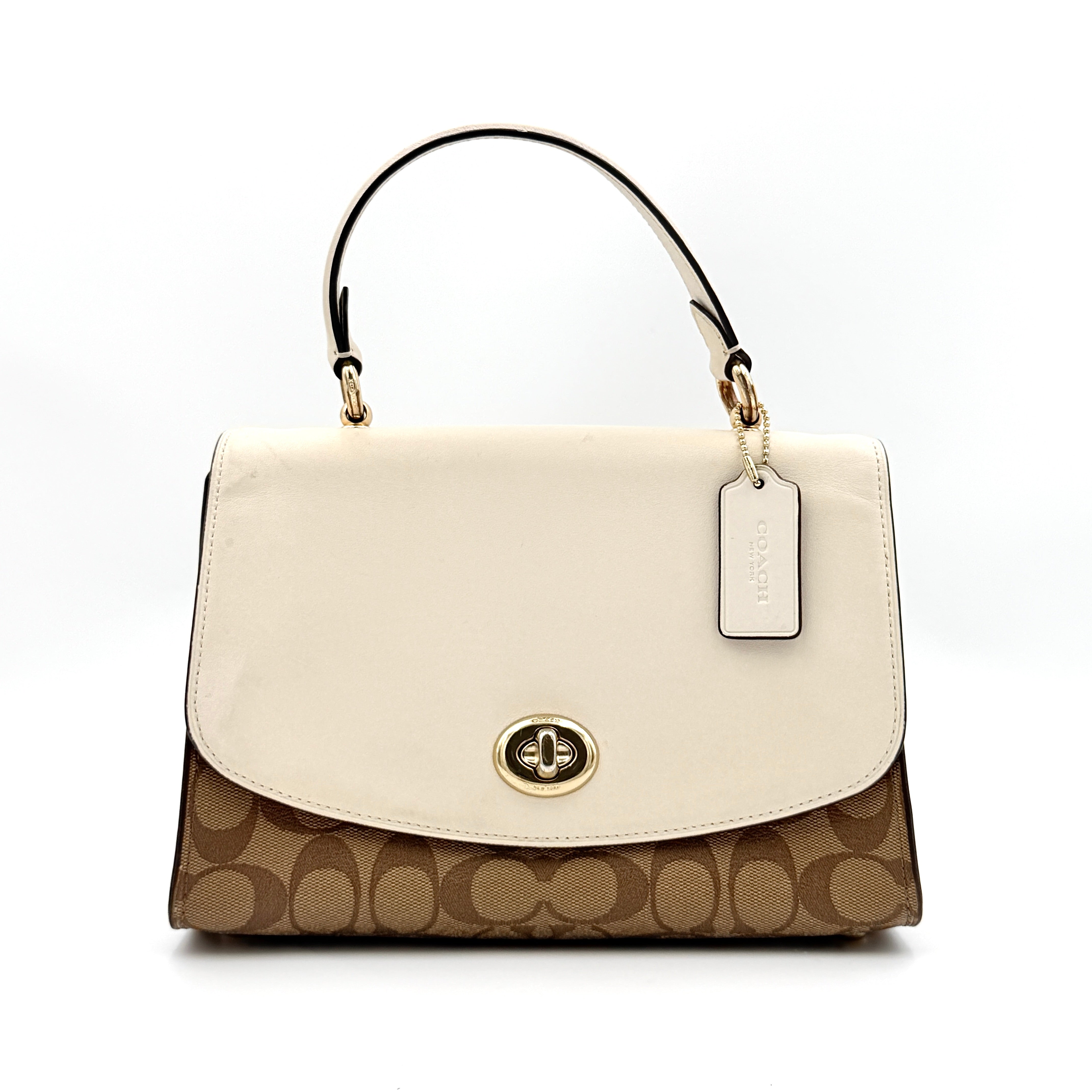 Coach Signature Tilly Top Handle Bag in beige and white with gold-tone hardware and detachable strap, displayed against a clean background.