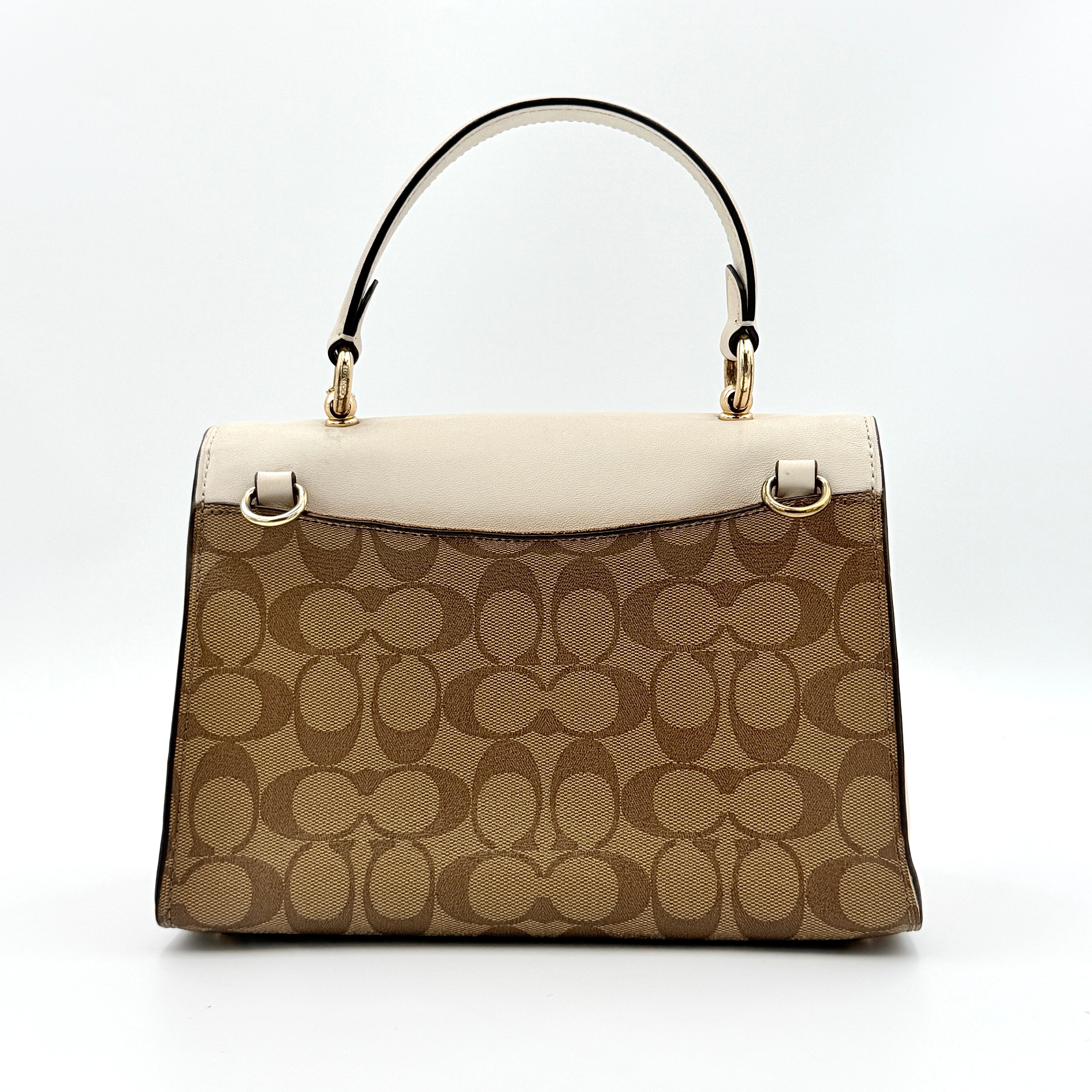 Coach Signature Tilly Top Handle Bag in beige and white with gold-tone hardware and detachable strap, displayed against a clean background.