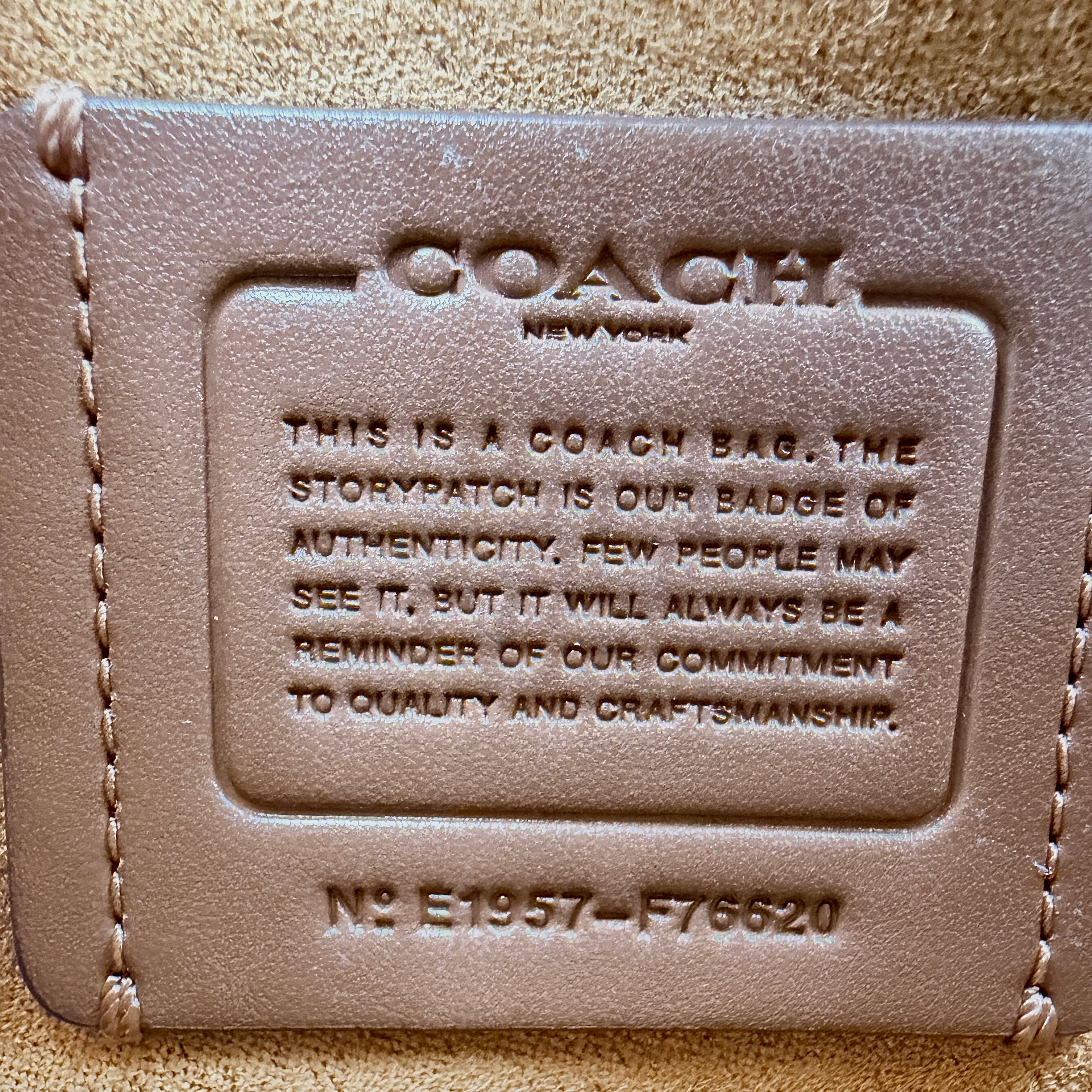 Coach Signature Tilly Top Handle Bag in beige and white with gold-tone hardware and detachable strap, displayed against a clean background.