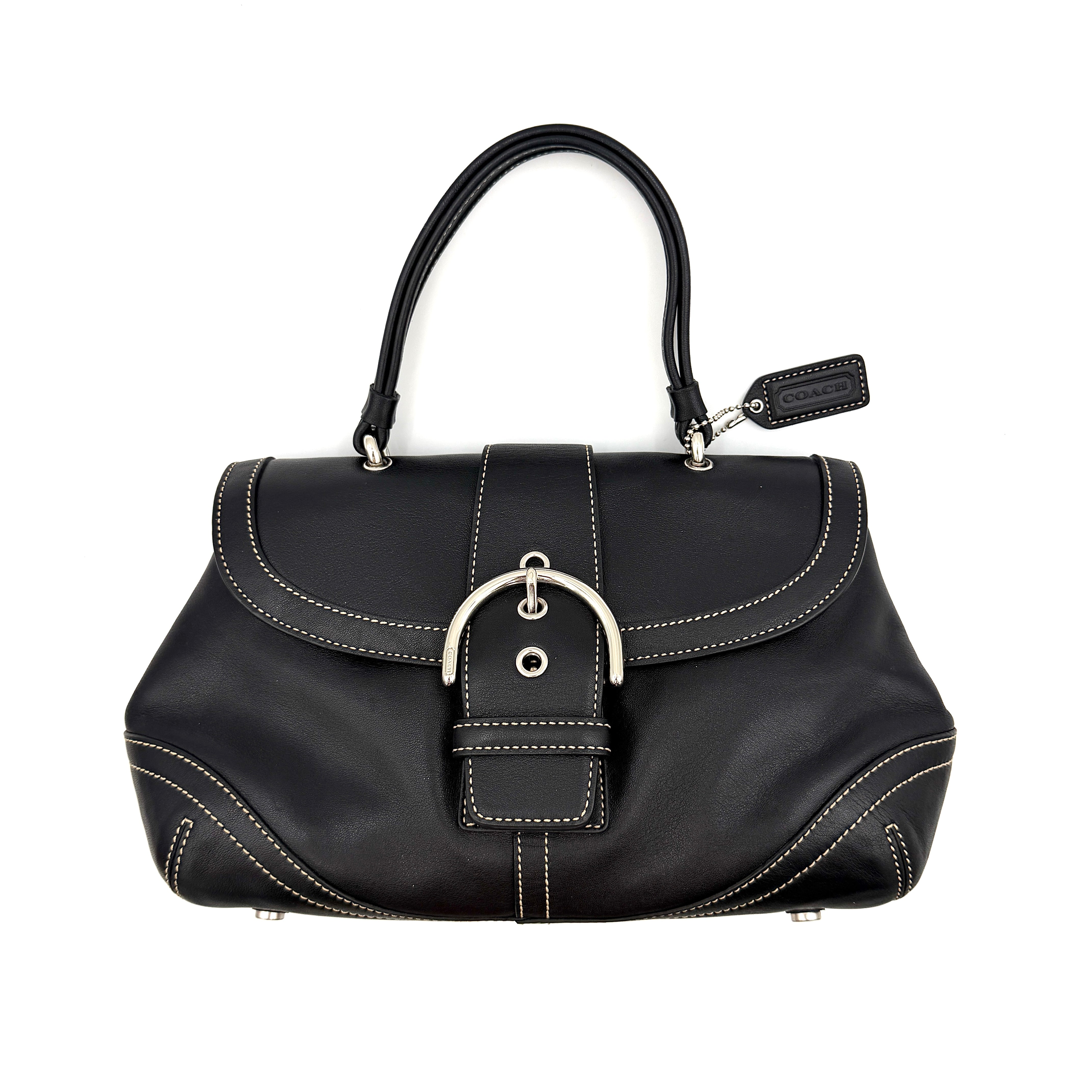 Coach Soho Buckle Top Handle Bag in black leather with contrast stitching and silver buckle, presented against a white background.
