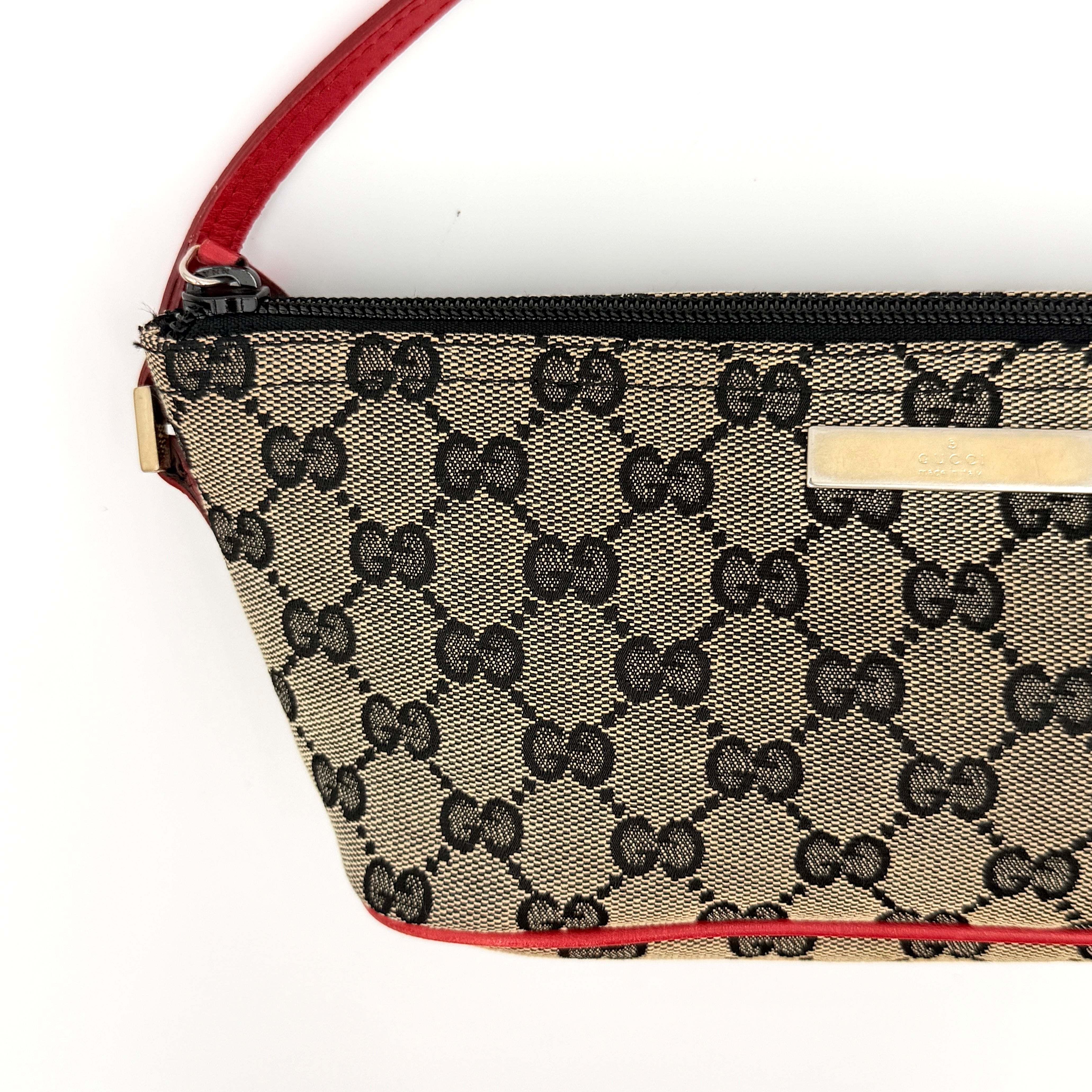 Gucci GG Monogram Pochette Boat Shoulder Bag in grey canvas with red leather trim and gold plaque, shown against a plain background.