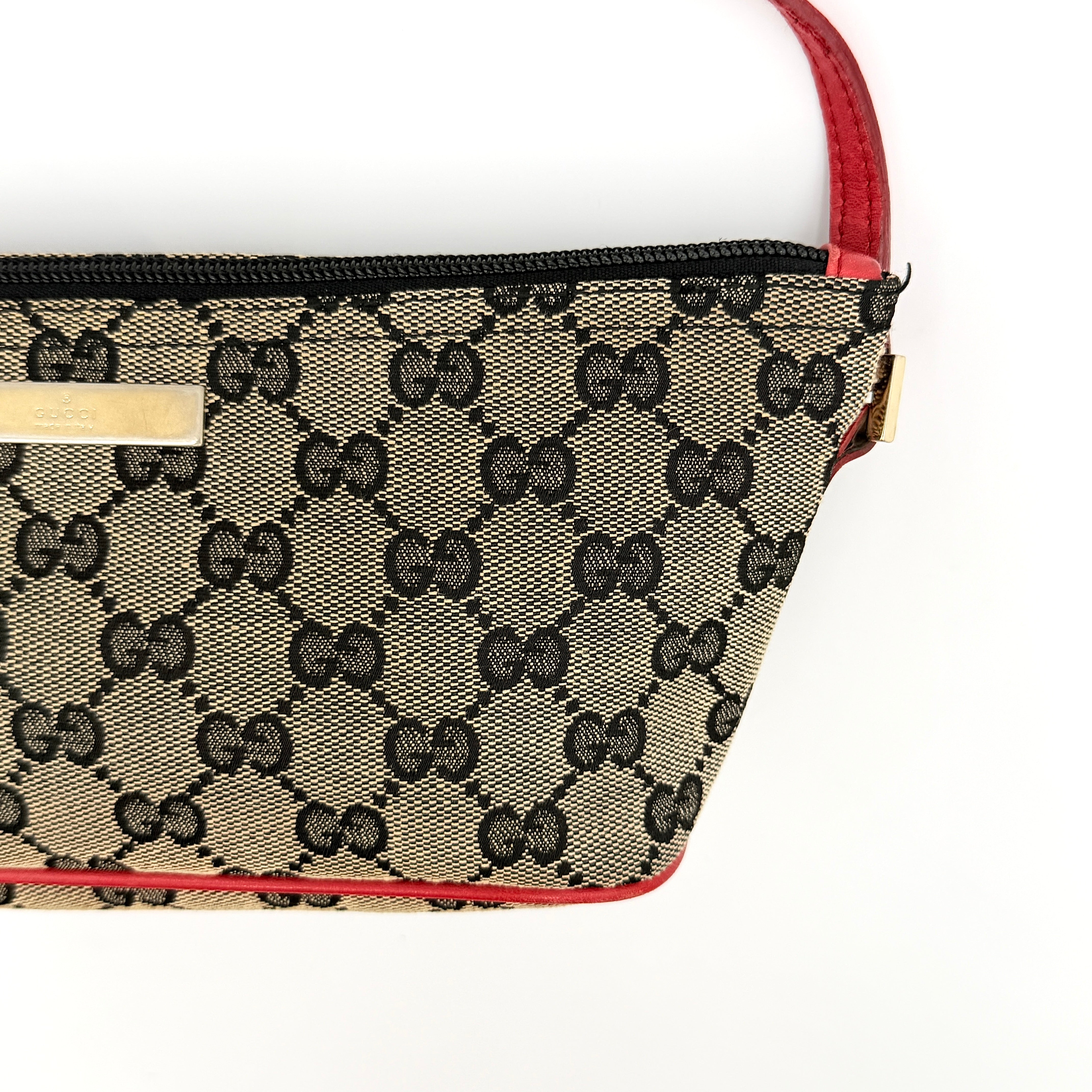 Gucci GG Monogram Pochette Boat Shoulder Bag in grey canvas with red leather trim and gold plaque, shown against a plain background.