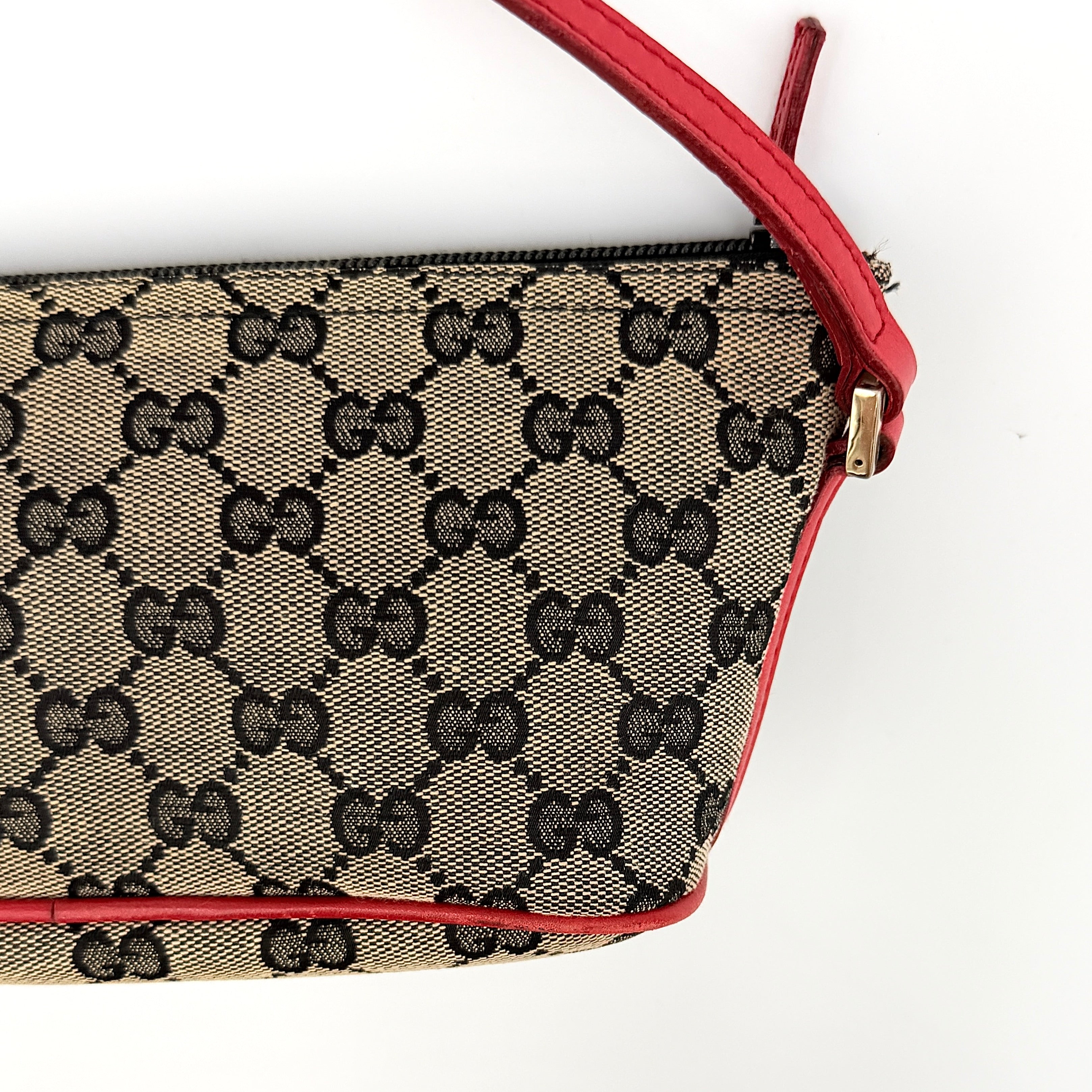 Gucci GG Monogram Pochette Boat Shoulder Bag in grey canvas with red leather trim and gold plaque, shown against a plain background.