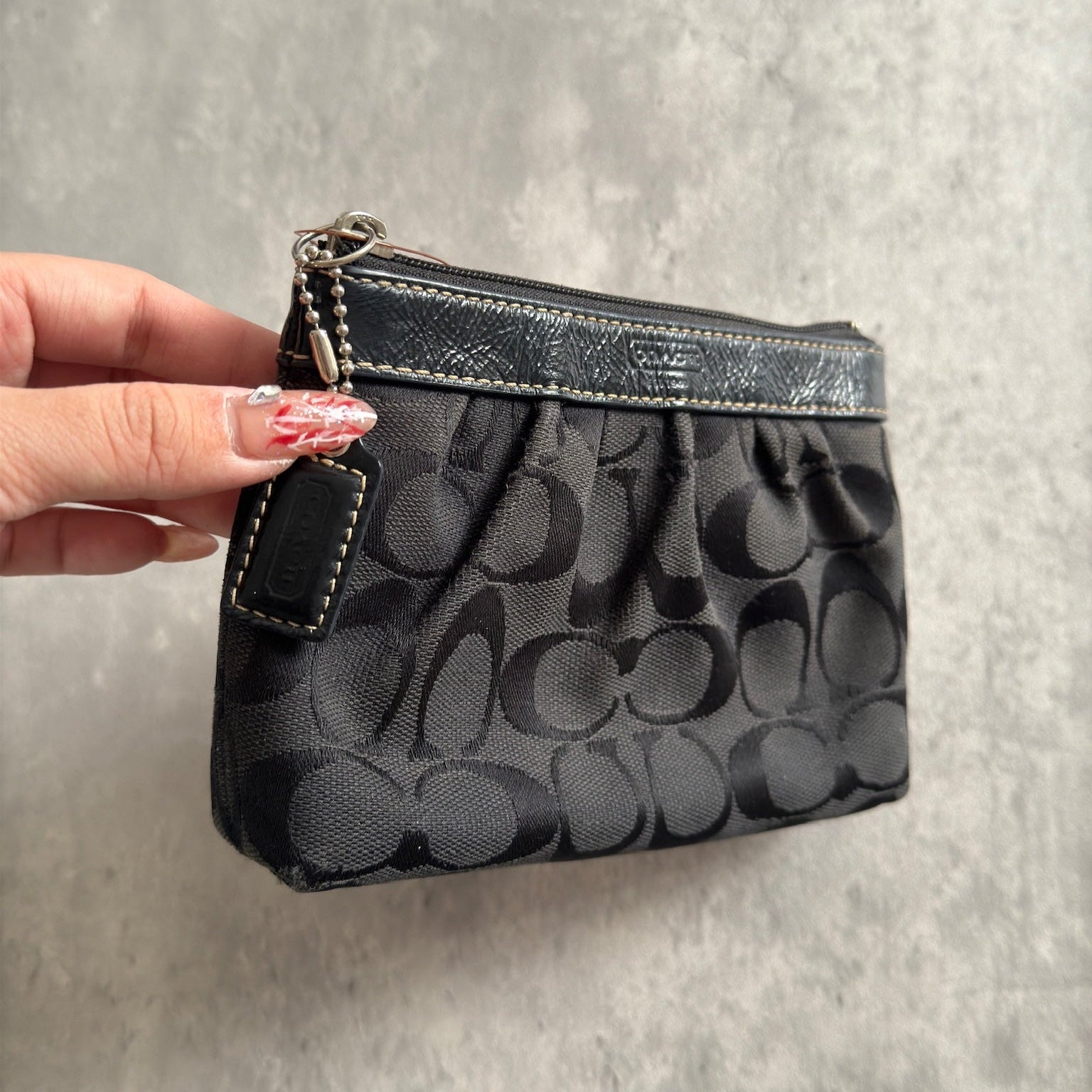 Coach Signature Pleated Black Wristlet with iconic monogram pattern, black leather trim, and red fabric interior, vintage condition.