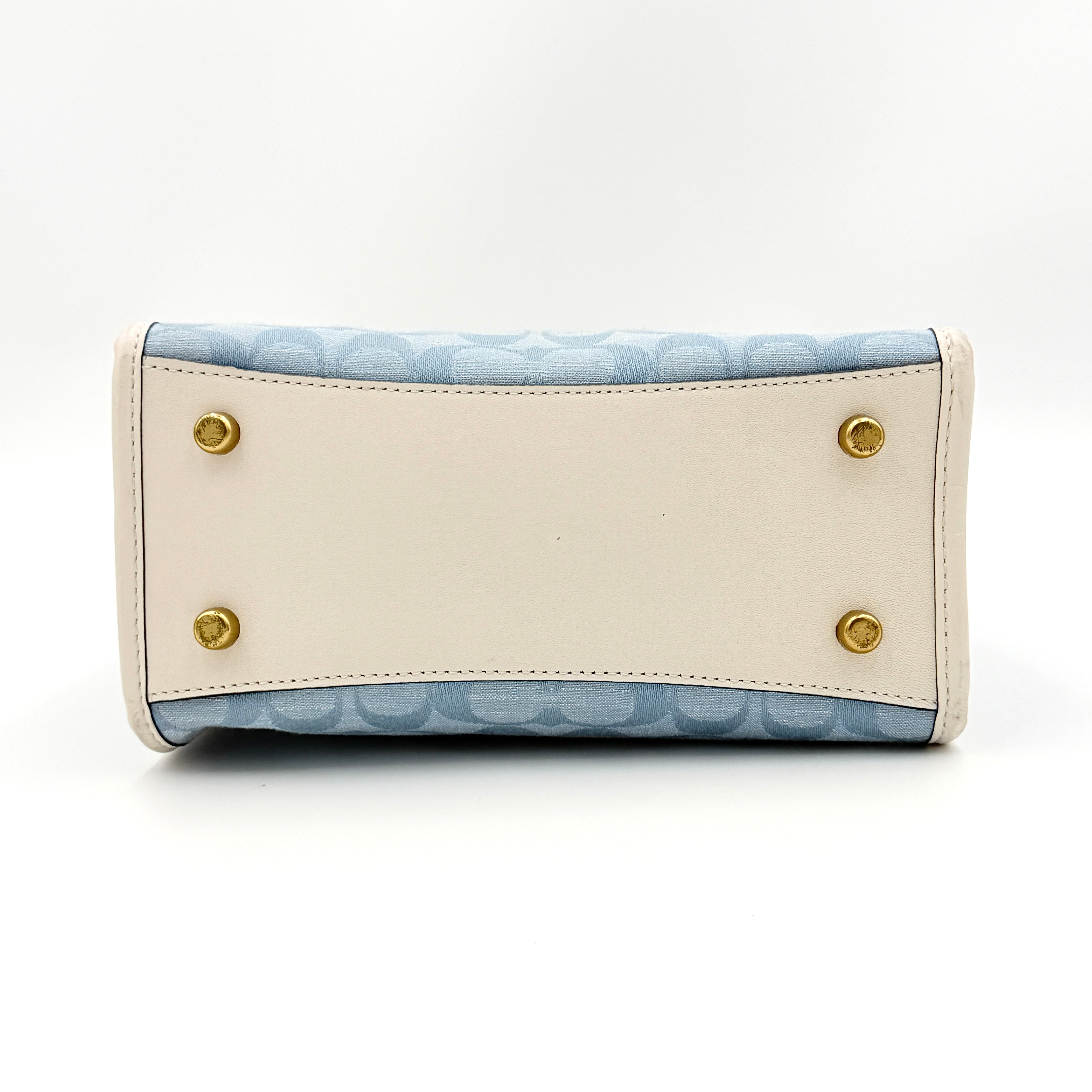 Coach Field Tote 22 in blue signature jacquard with white leather trim and detachable strap, styled for versatile wear.