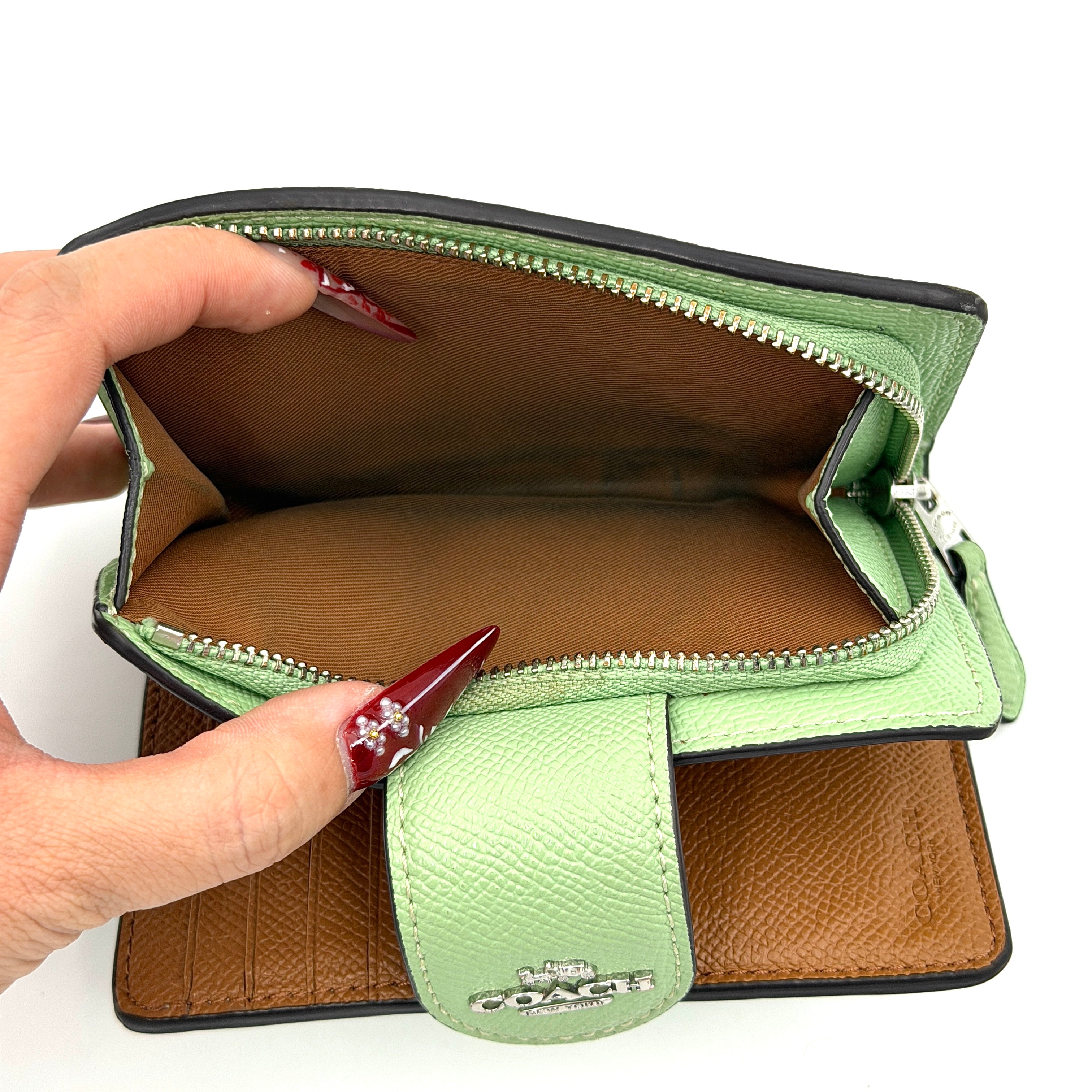 Coach Medium Corner Zip Wallet in fresh green pebbled leather with silver logo hardware and organised tan interior.