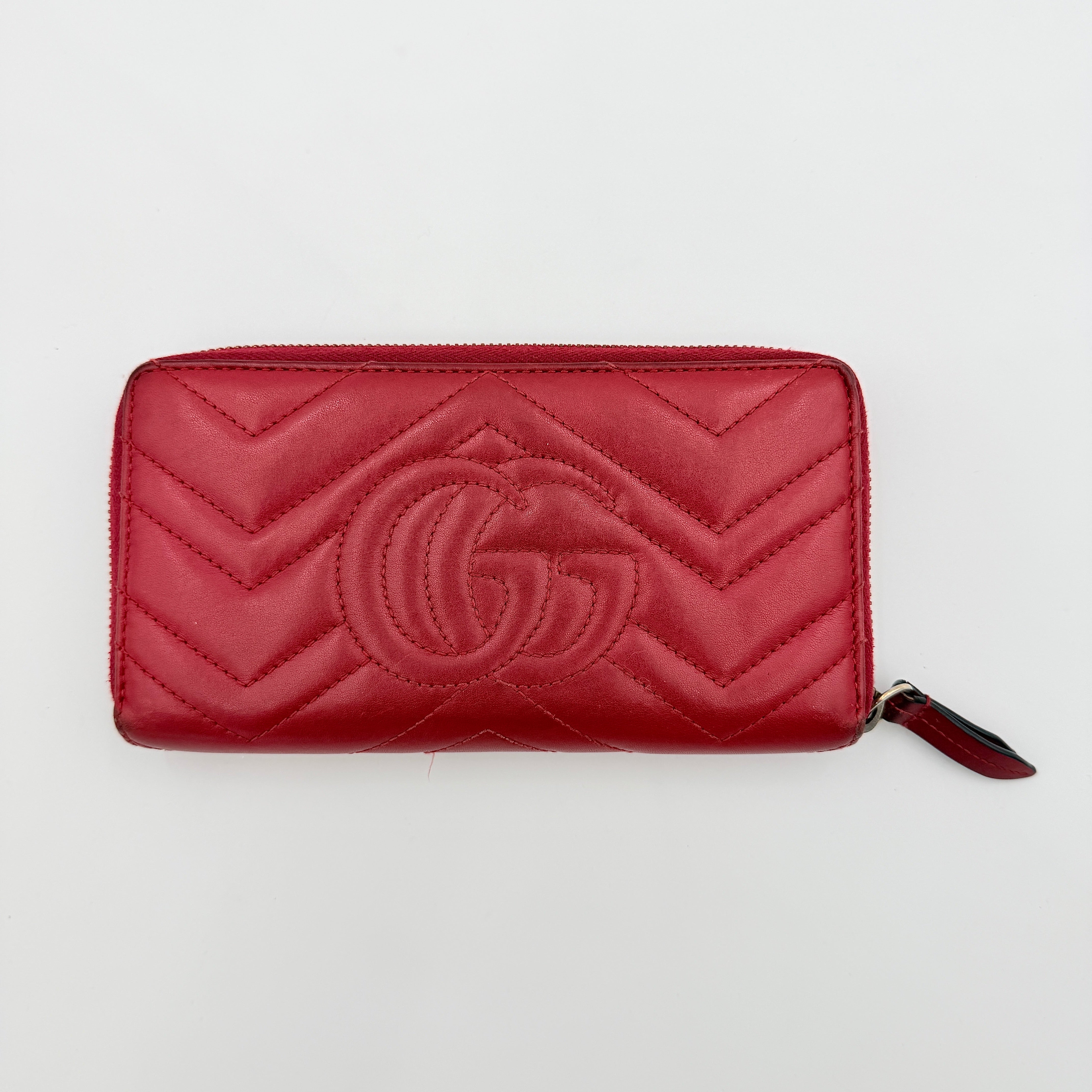 Gucci GG Marmont quilted long wallet in red leather with gold hardware displayed flat against a white background.