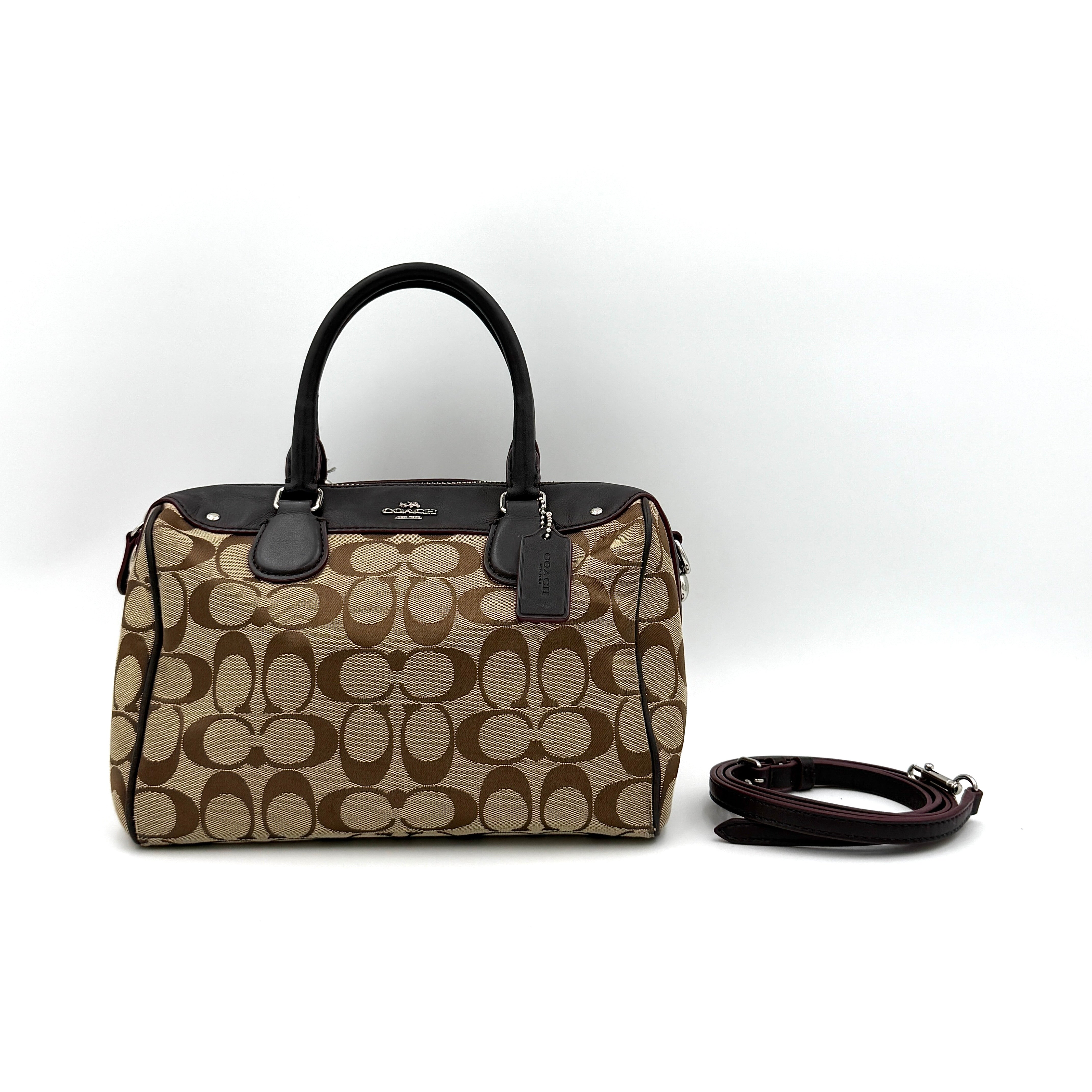 Coach Mini Bennett Boston Bag in beige monogram canvas with brown leather trim, dual handles, and detachable crossbody strap.