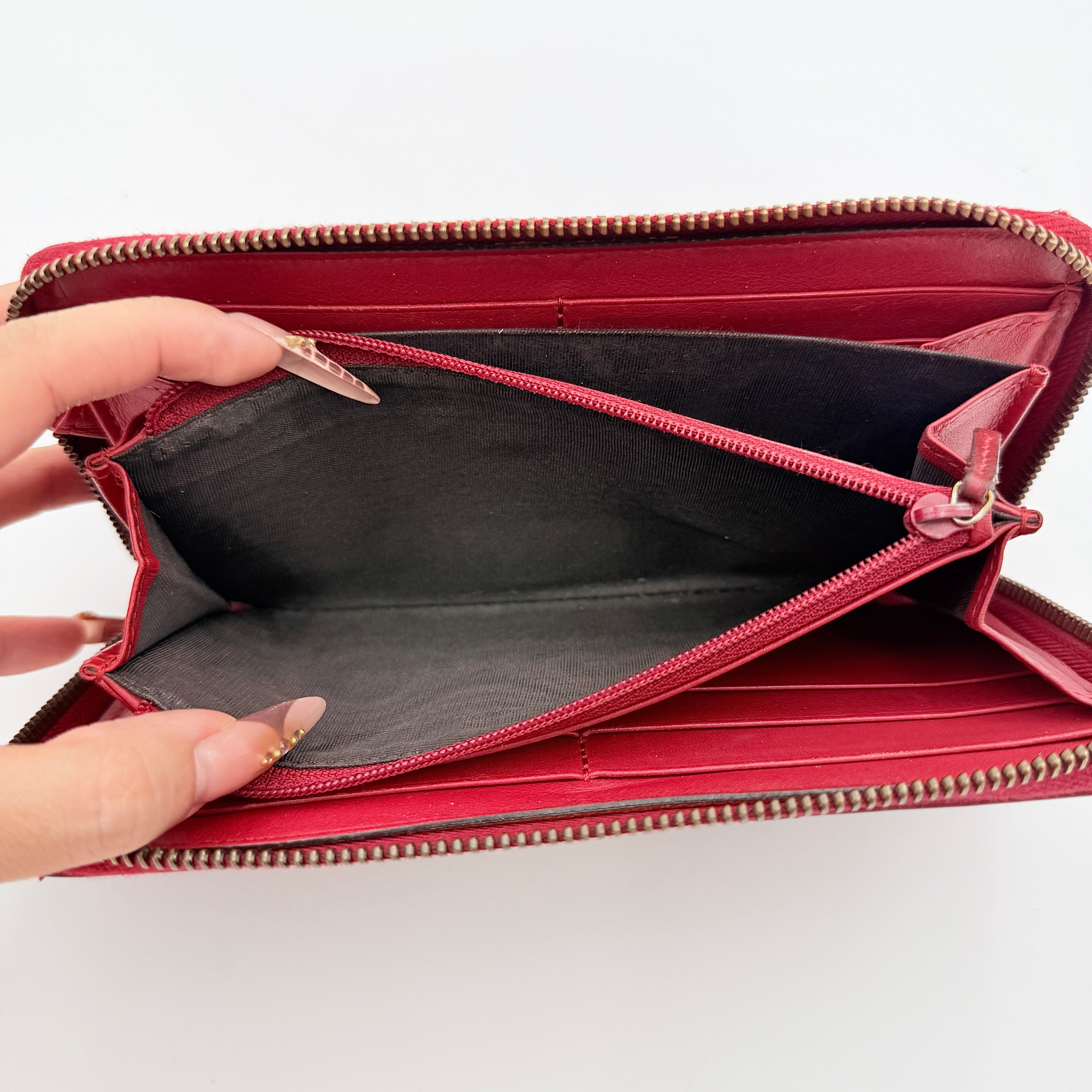 Gucci GG Marmont quilted long wallet in red leather with gold hardware displayed flat against a white background.
