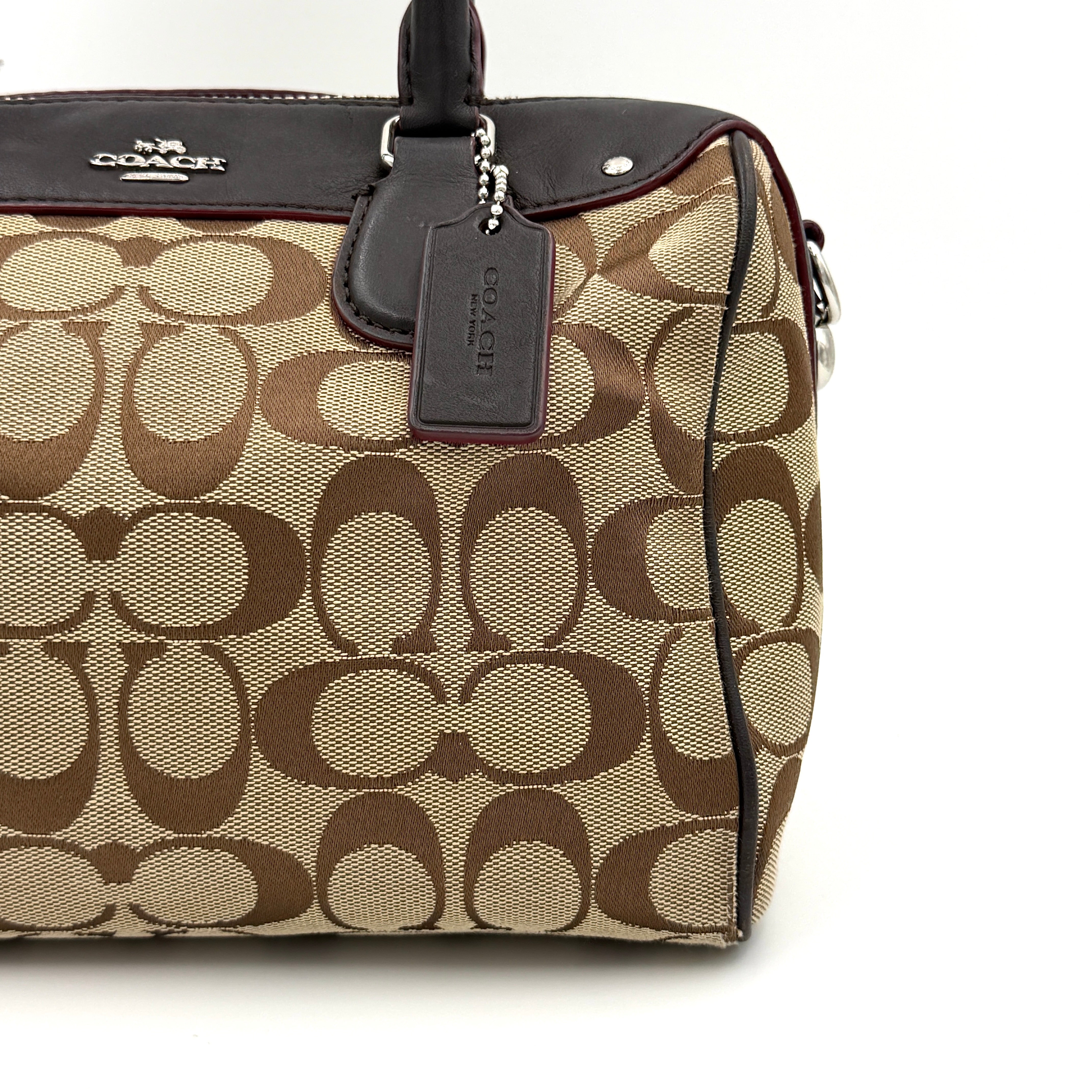 Coach Mini Bennett Boston Bag in beige monogram canvas with brown leather trim, dual handles, and detachable crossbody strap.