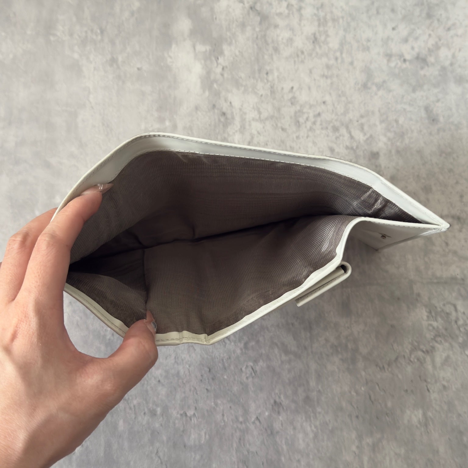 Prada City Calf Leather Compact Wallet in off-white with flap closure and embossed logo detail, showcasing a sophisticated, minimalist design.