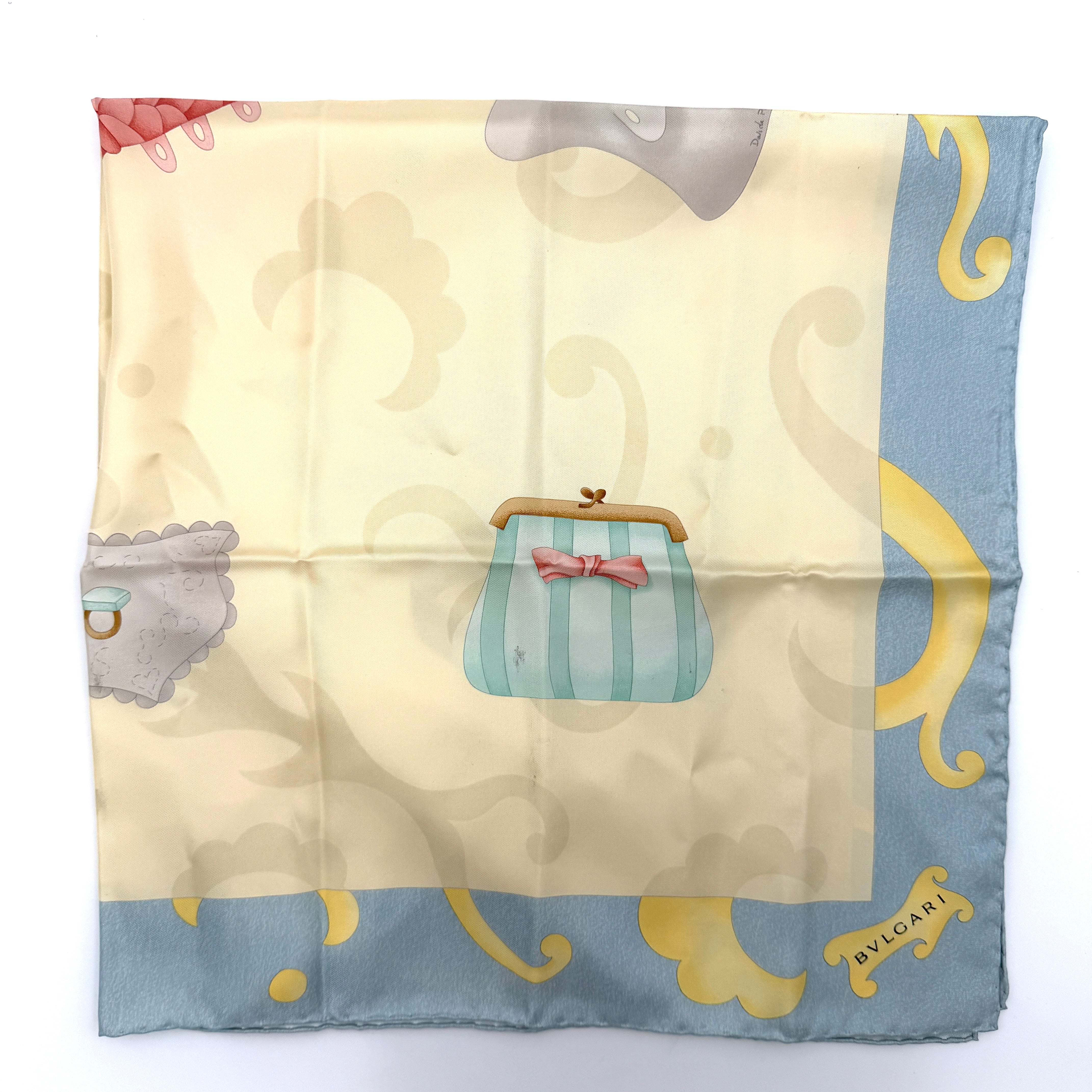 Bvlgari silk scarf in light blue and cream, featuring playful accessory illustrations and baroque-style borders.