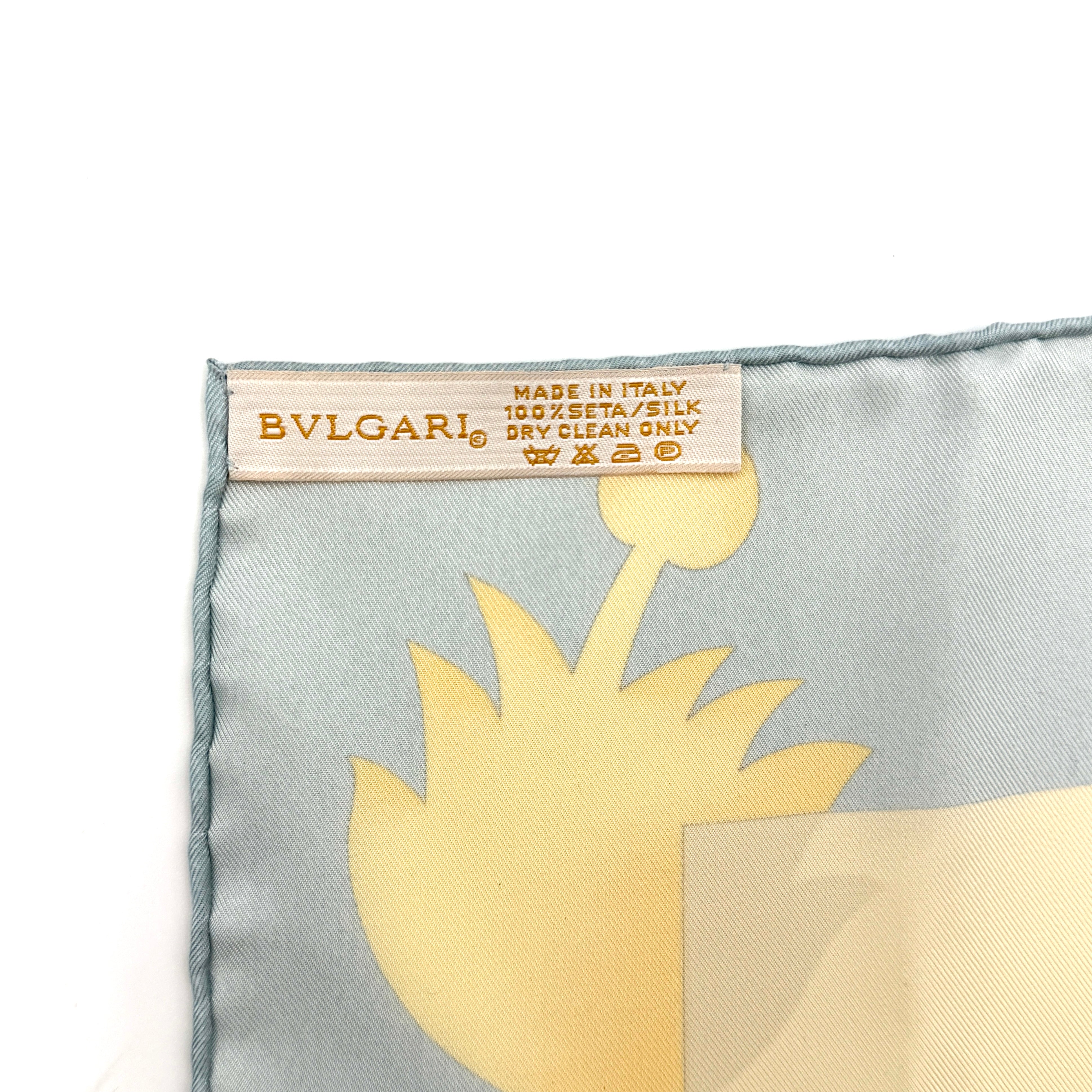 Bvlgari silk scarf in light blue and cream, featuring playful accessory illustrations and baroque-style borders.