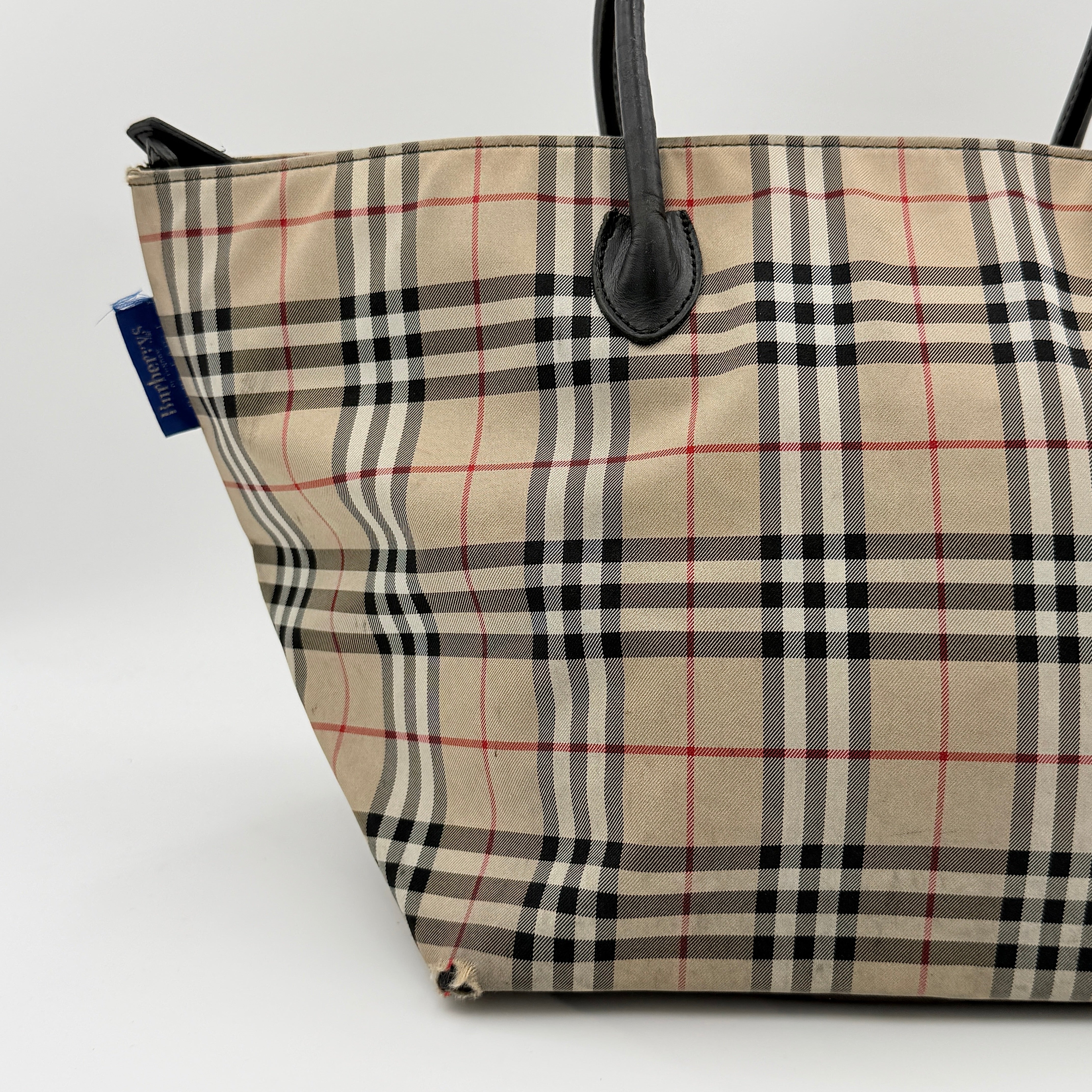 Burberry Nova Check shoulder bag in beige and black with black leather handles and zip closure.