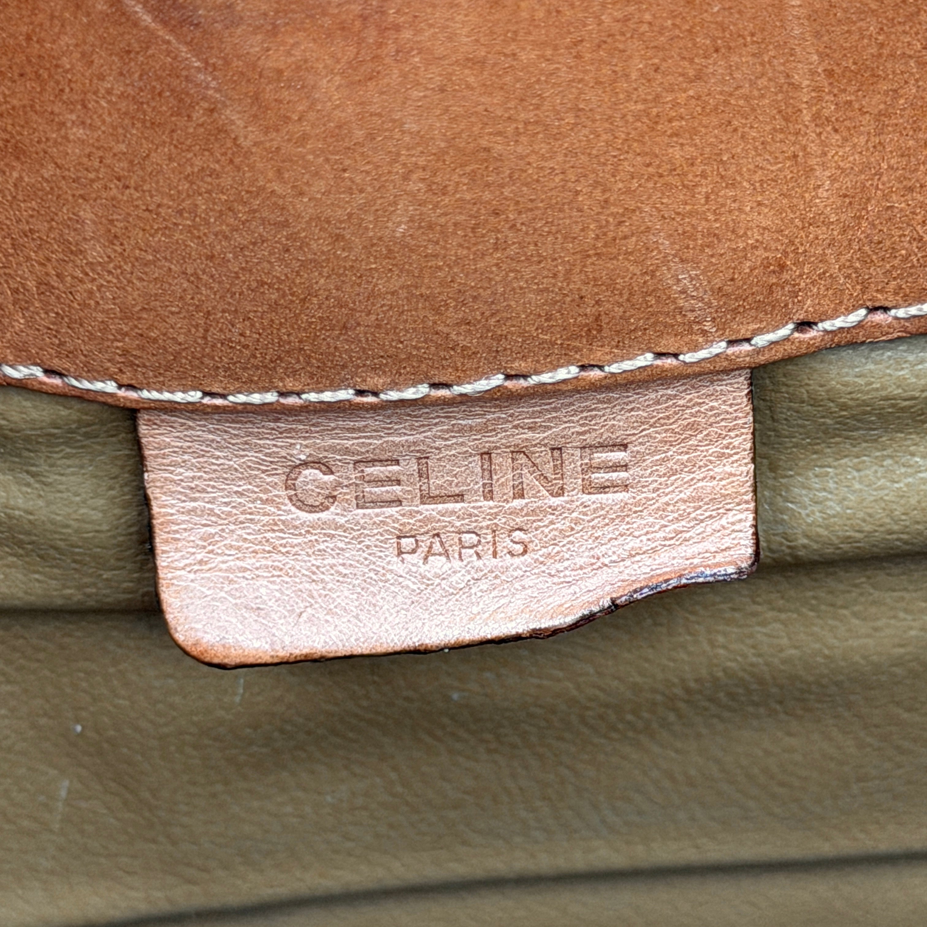 The Celine Macadam Clutch Bag in beige, featuring the iconic monogram canvas and tan leather trim, shown neatly closed with its signature emblem on the flap.