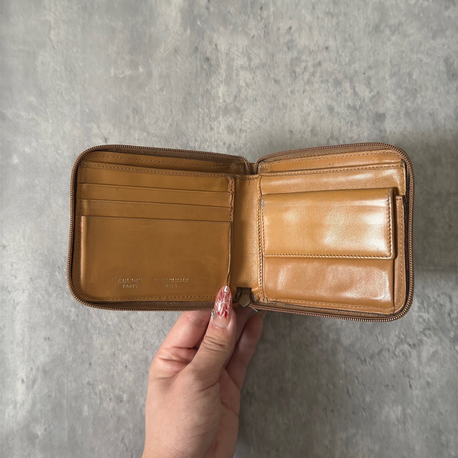 Celine Signature Macadam Triomphe Wallet in beige canvas with brown leather details, featuring multiple organizational compartments, embodying classic elegance and functionality.