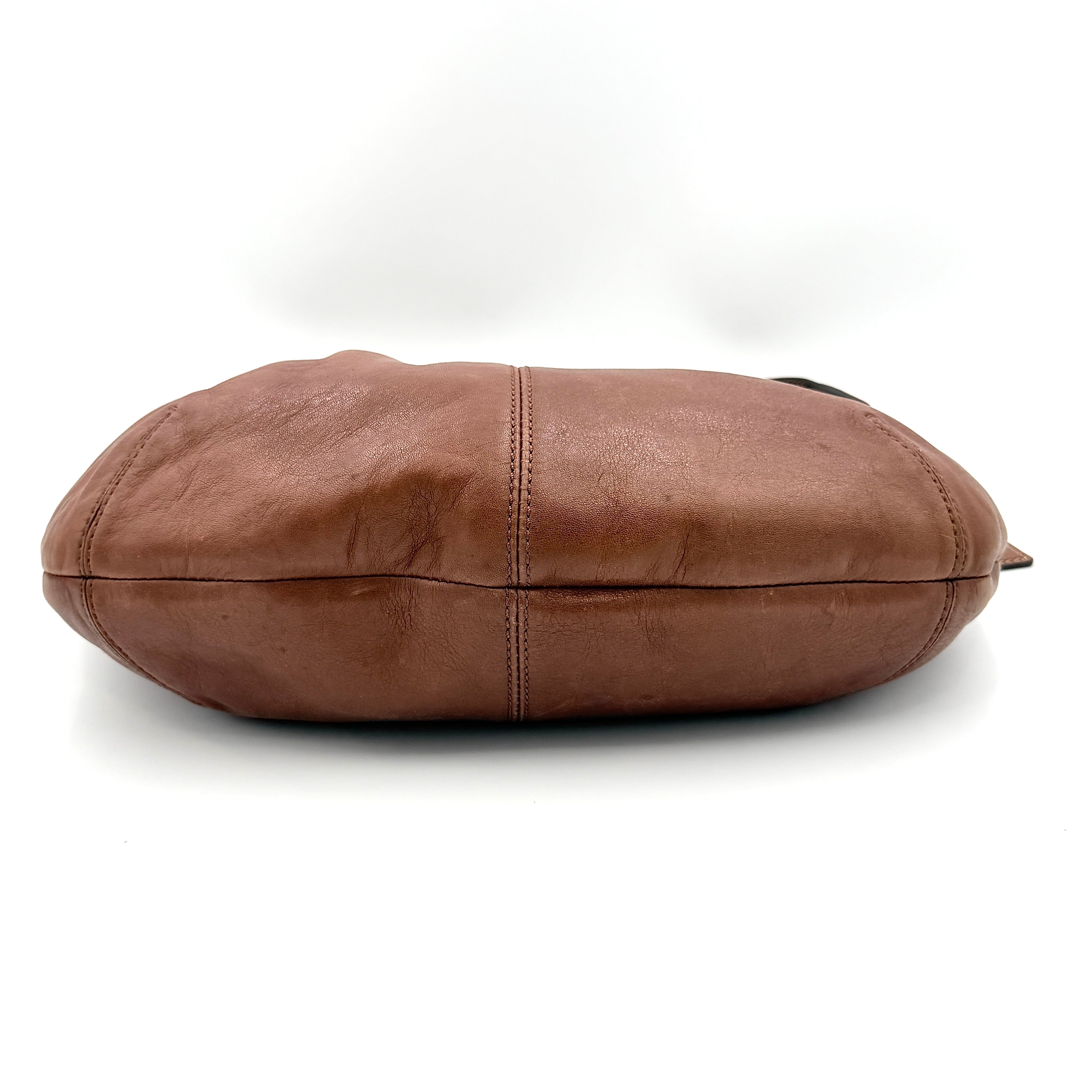 Coach Soho Hobo brown leather shoulder bag with pleated detailing and silver hardware, shown on a white background.