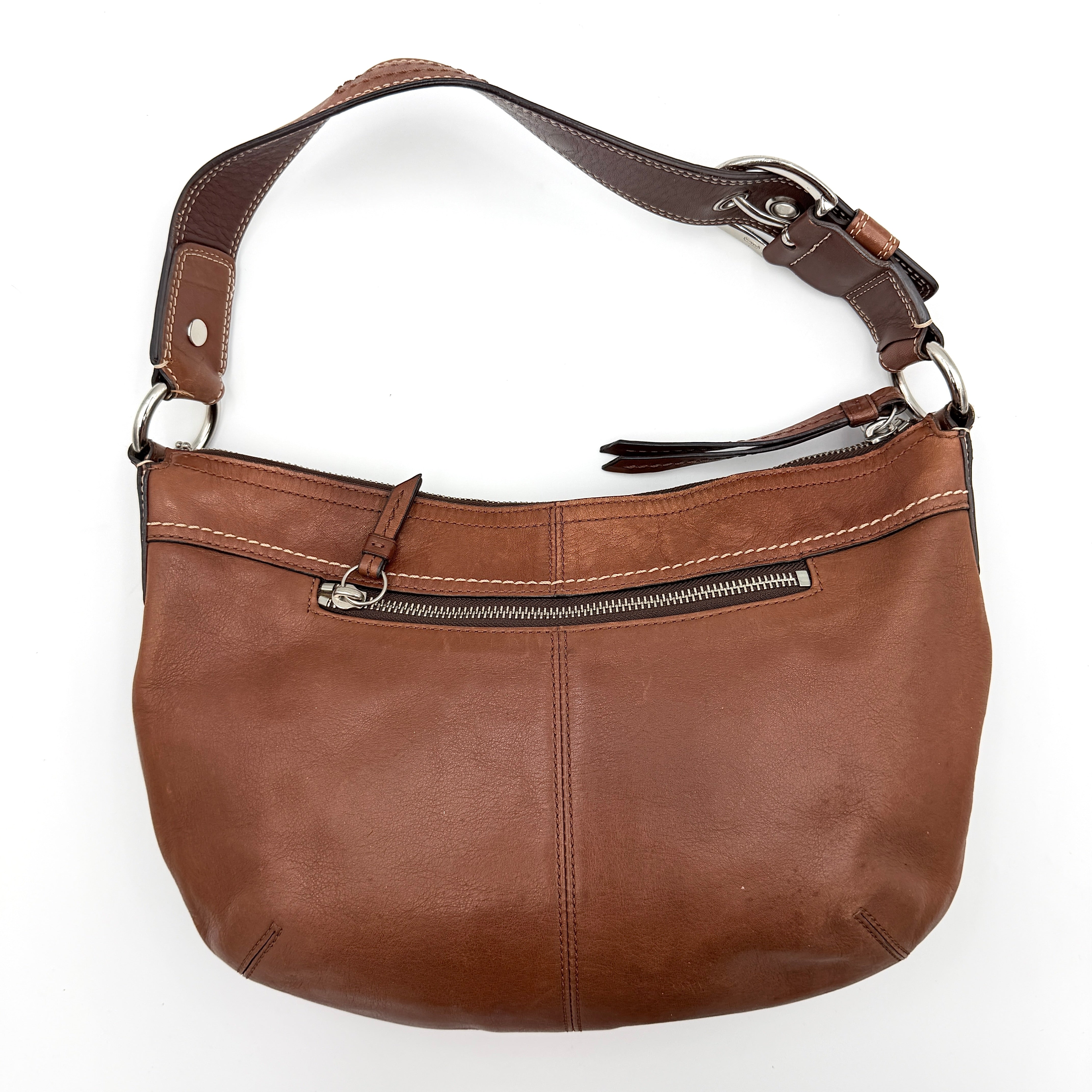 Coach Soho Hobo brown leather shoulder bag with pleated detailing and silver hardware, shown on a white background.