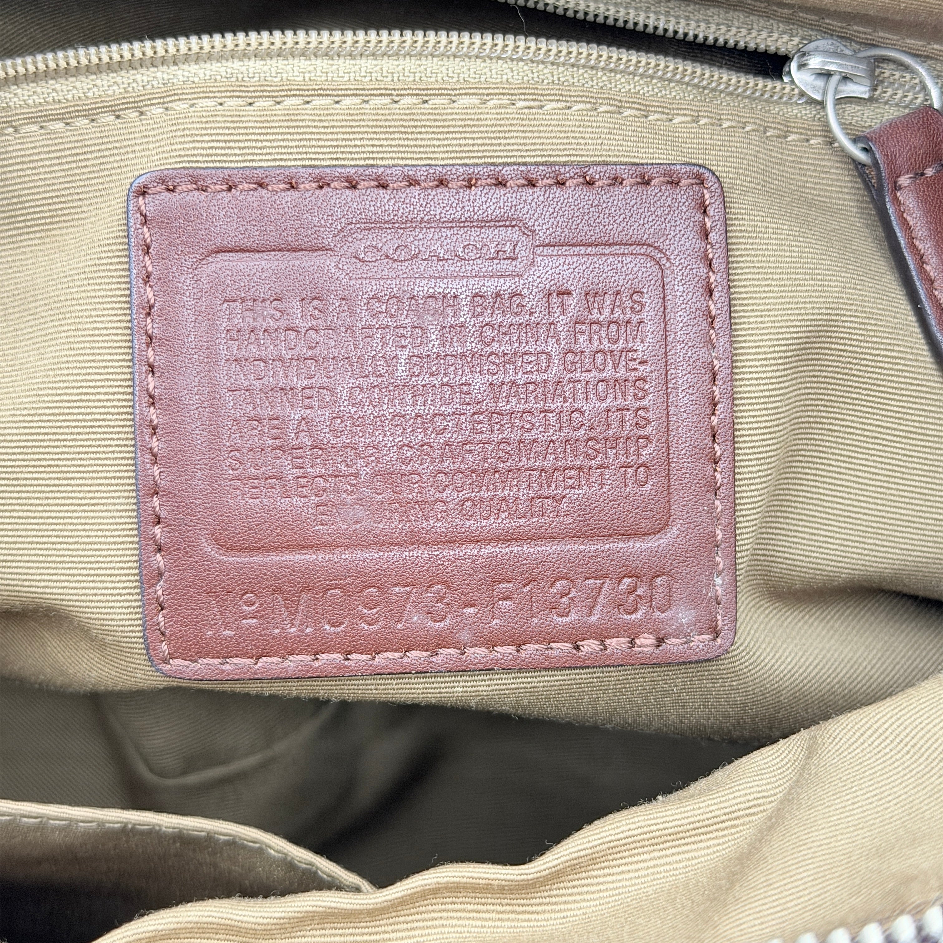 Coach Soho Hobo brown leather shoulder bag with pleated detailing and silver hardware, shown on a white background.