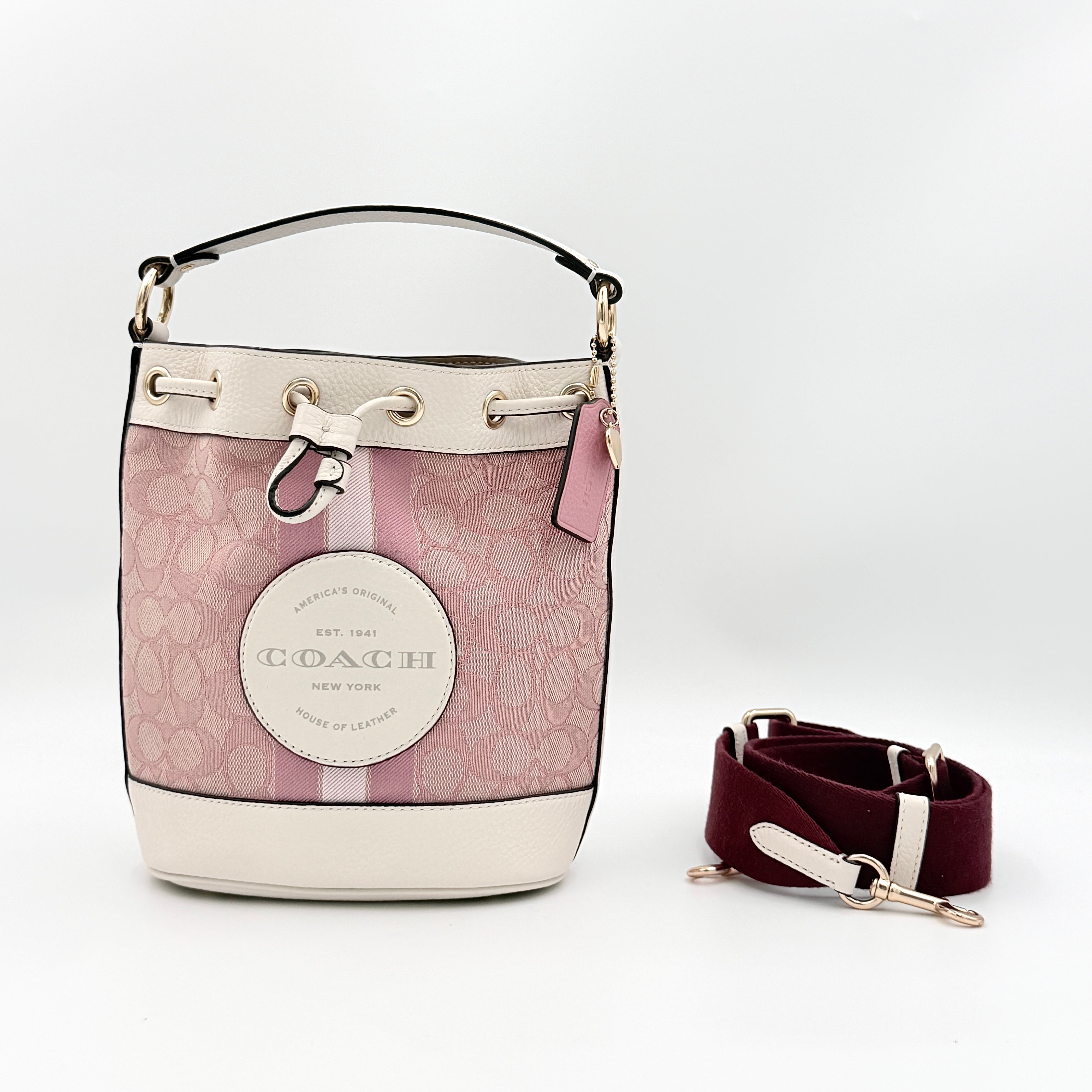 Coach Signature Dempsey 19 bucket bag in pink and white canvas with white leather trim and detachable strap.