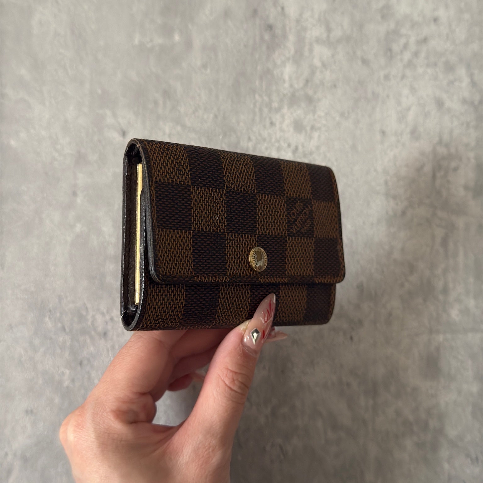 Pre-loved Louis Vuitton Damier Ebene Key Holder with Six Gold-Tone Hooks, Luxury Vintage Designer Accessory with Snap Button Closure.