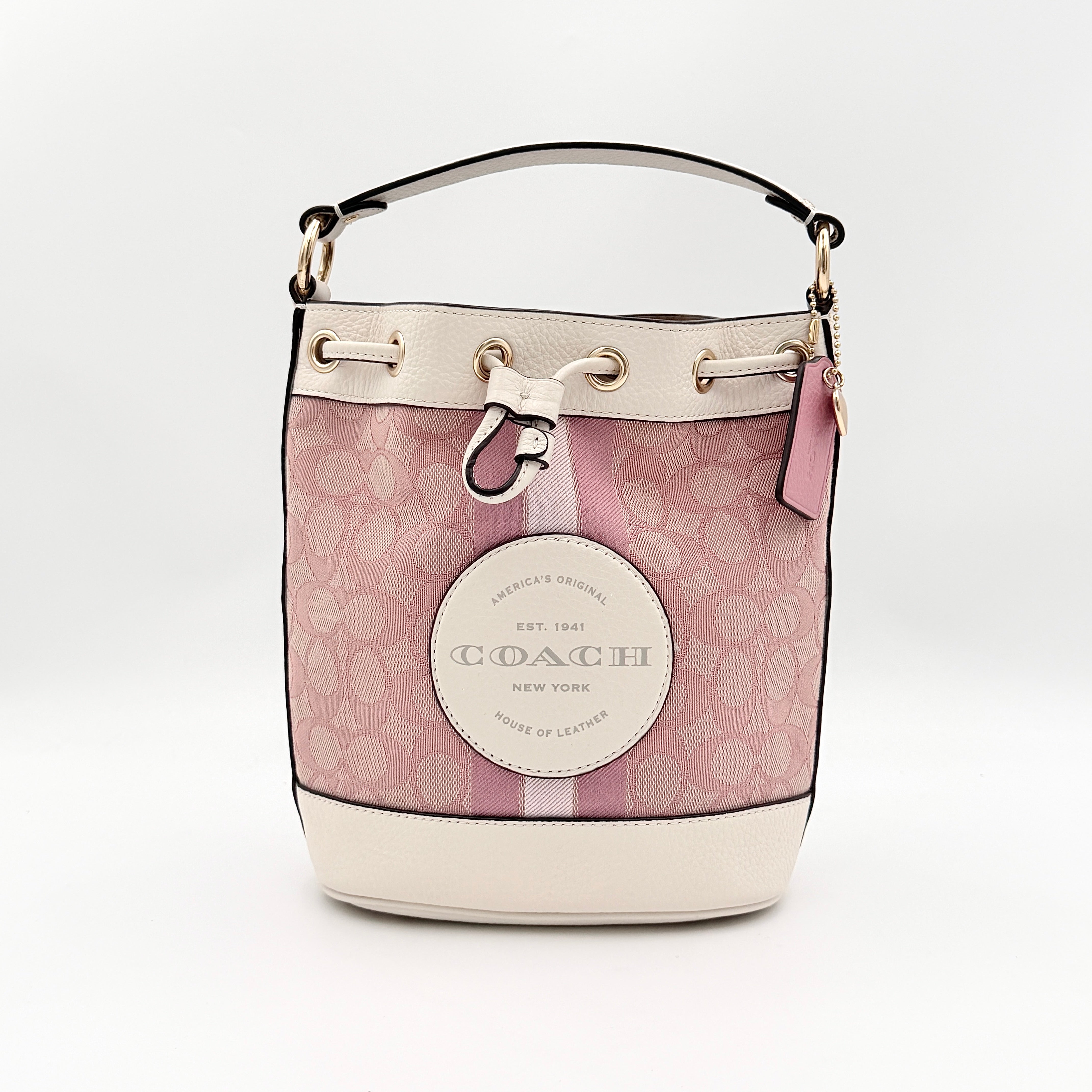 Coach Signature Dempsey 19 bucket bag in pink and white canvas with white leather trim and detachable strap.