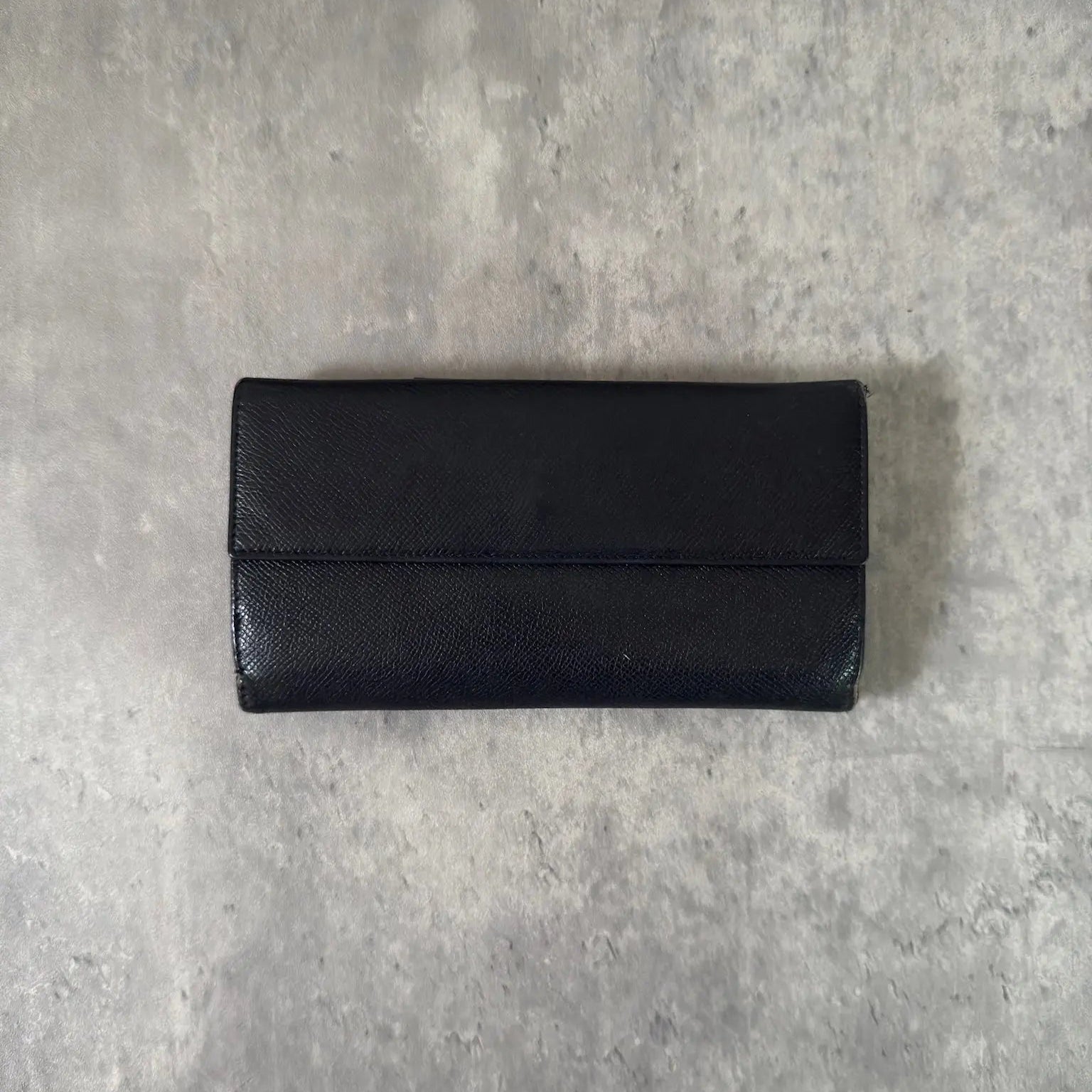 BVLGARI Classico Long Wallet in black leather, featuring a silver-tone logo clasp, multiple card slots, and a spacious bill compartment, showcasing understated luxury and sophistication.