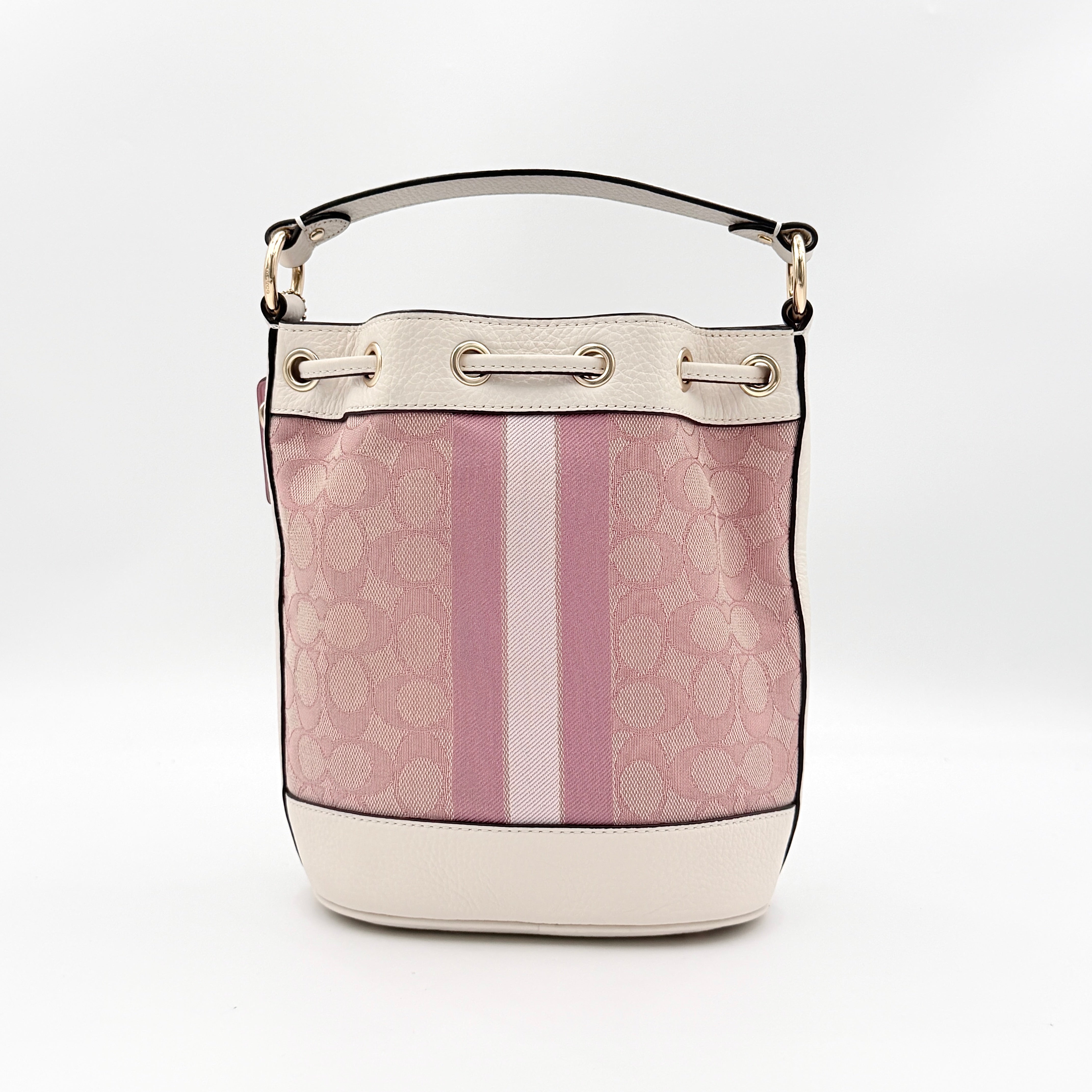 Coach Signature Dempsey 19 bucket bag in pink and white canvas with white leather trim and detachable strap.
