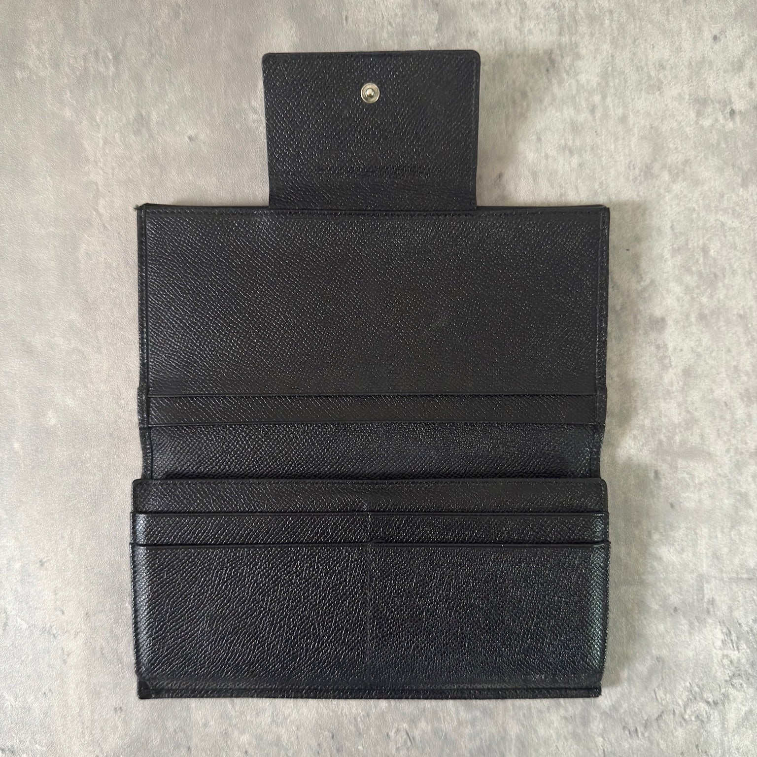 Bvlgari Classico Long Wallet in black leather, featuring a silver-tone logo clasp, multiple card slots, and a spacious bill compartment, showcasing understated luxury and sophistication.