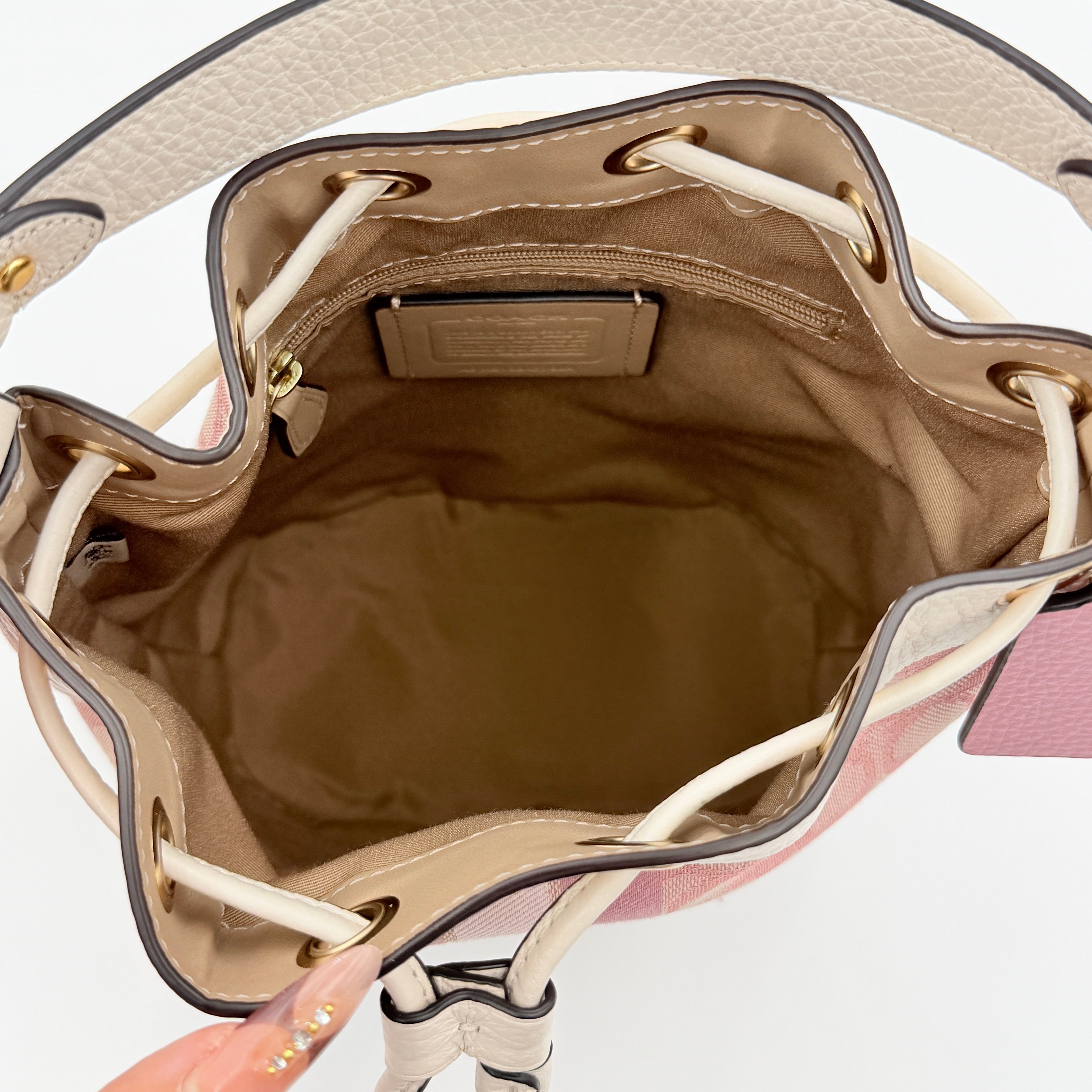 Coach Signature Dempsey 19 bucket bag in pink and white canvas with white leather trim and detachable strap.
