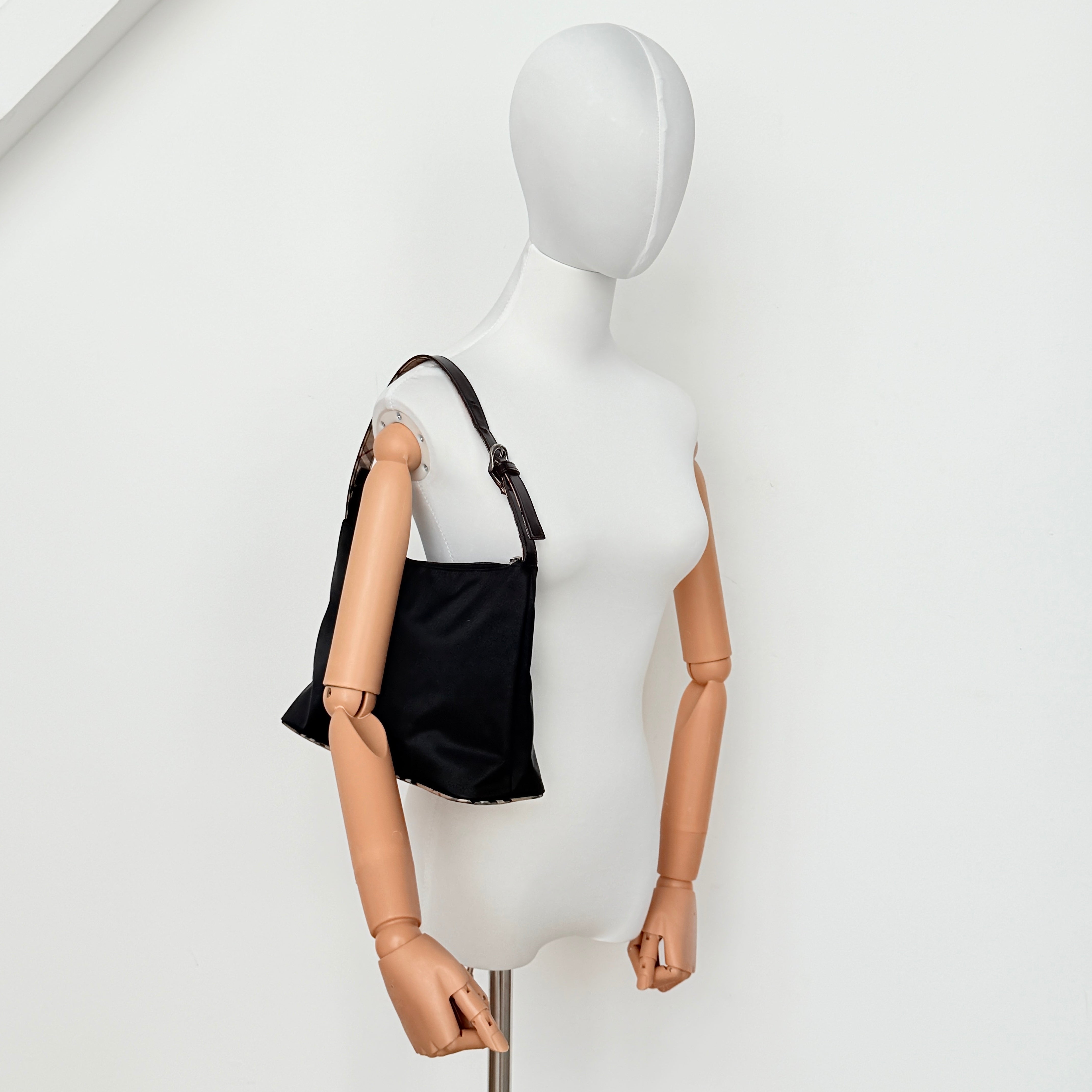 Front-facing Burberry Nova Check Nylon Shoulder Bag in black with Nova Check strap and base, shown against a clean background.