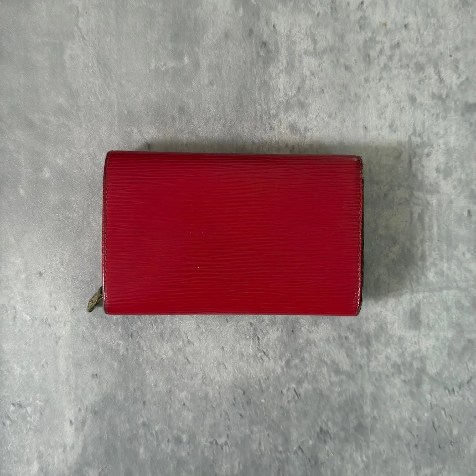Louis Vuitton International Wallet in red Epi leather, featuring embossed LV logo, textured surface, multiple card slots, and gold-tone hardware. Compact and elegant, perfect for daily use.