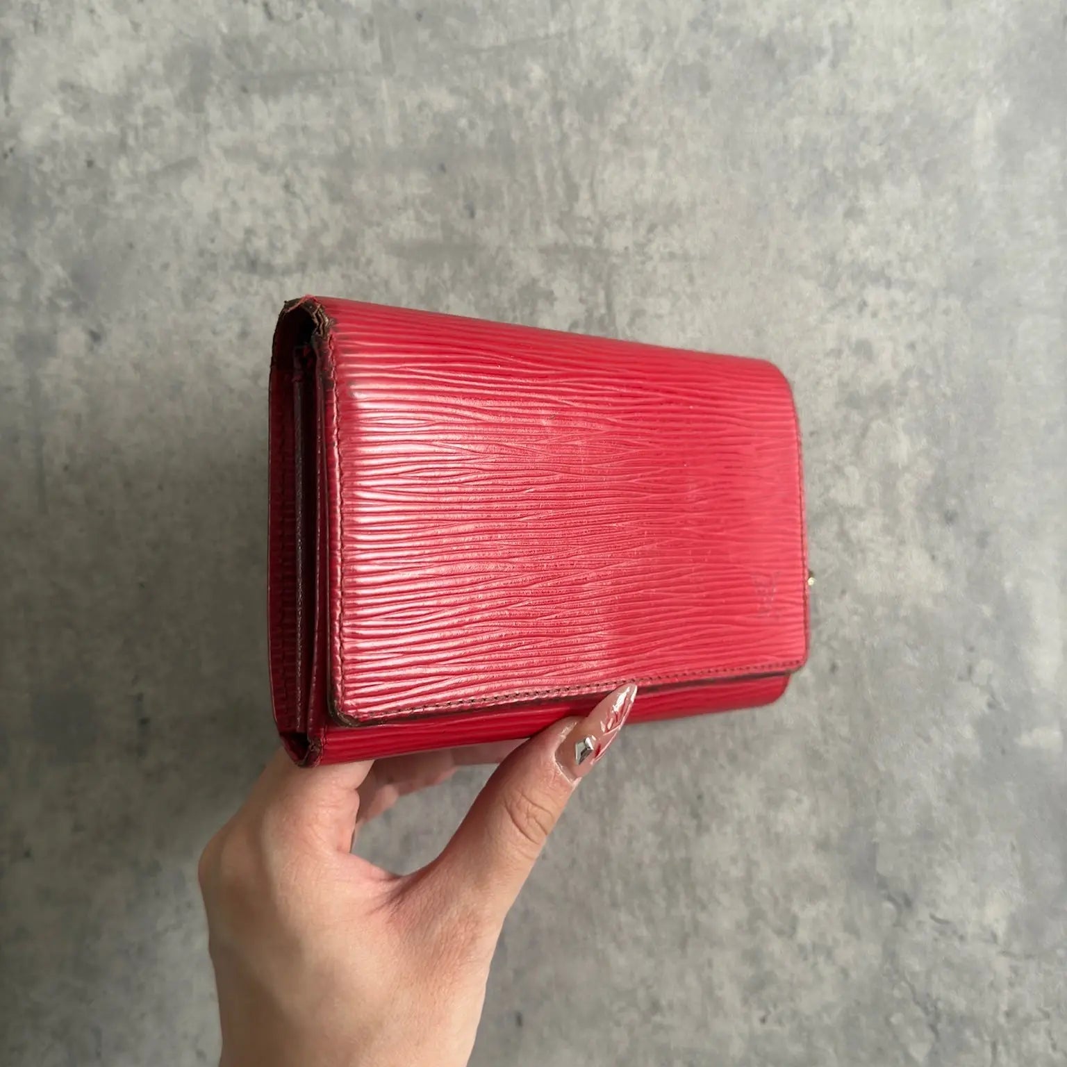 Louis Vuitton International Wallet in red Epi leather, featuring embossed LV logo, textured surface, multiple card slots, and gold-tone hardware. Compact and elegant, perfect for daily use.
